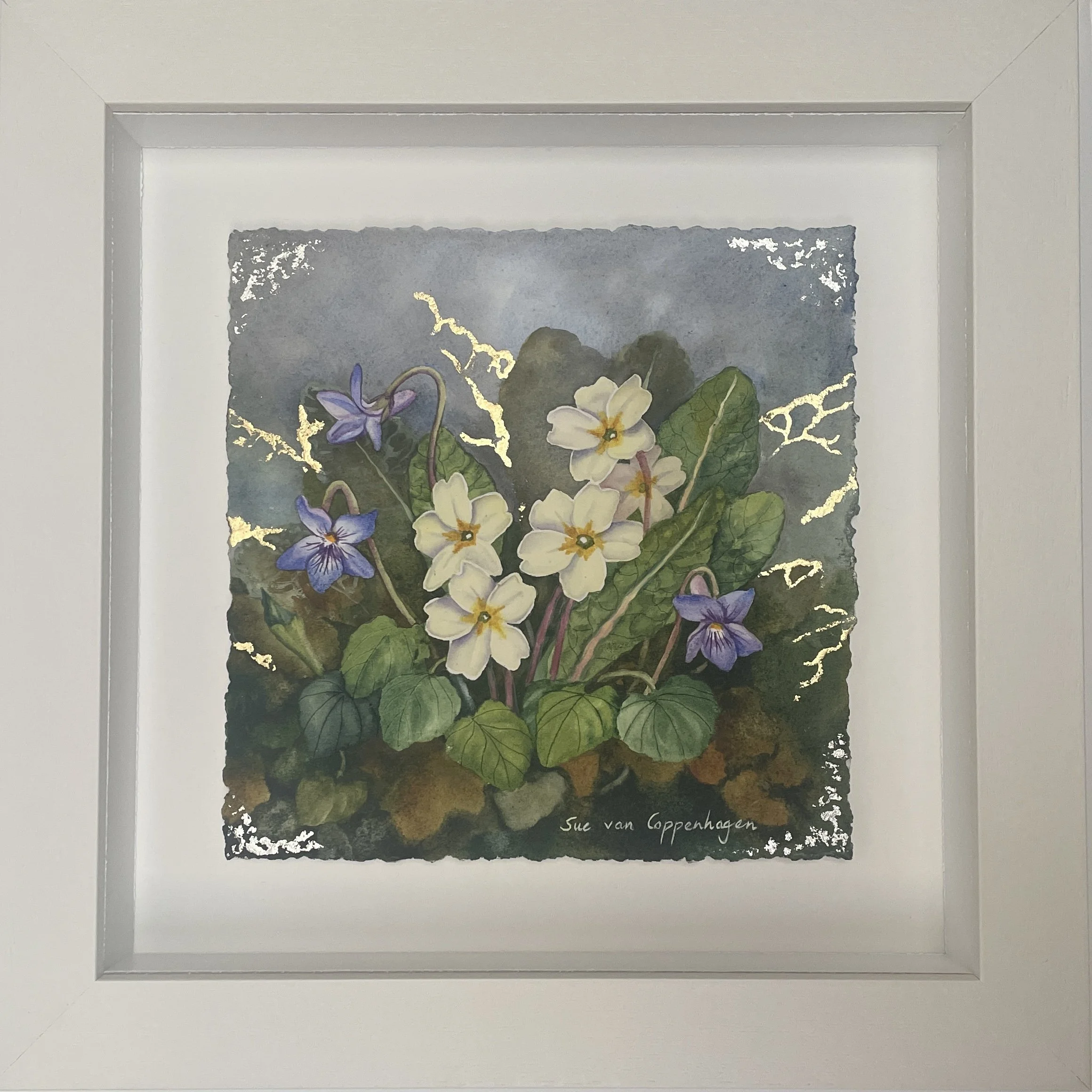 Painting of violet flowers and pale yellow primroses on a rich background with gold leaf detailing, framed in a wide off-white frame