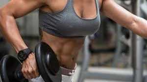 Close-up of a woman lifting a dumbbell during a workout at the gym.