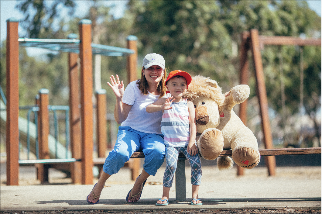 woman and child with giant teddy bear at playground