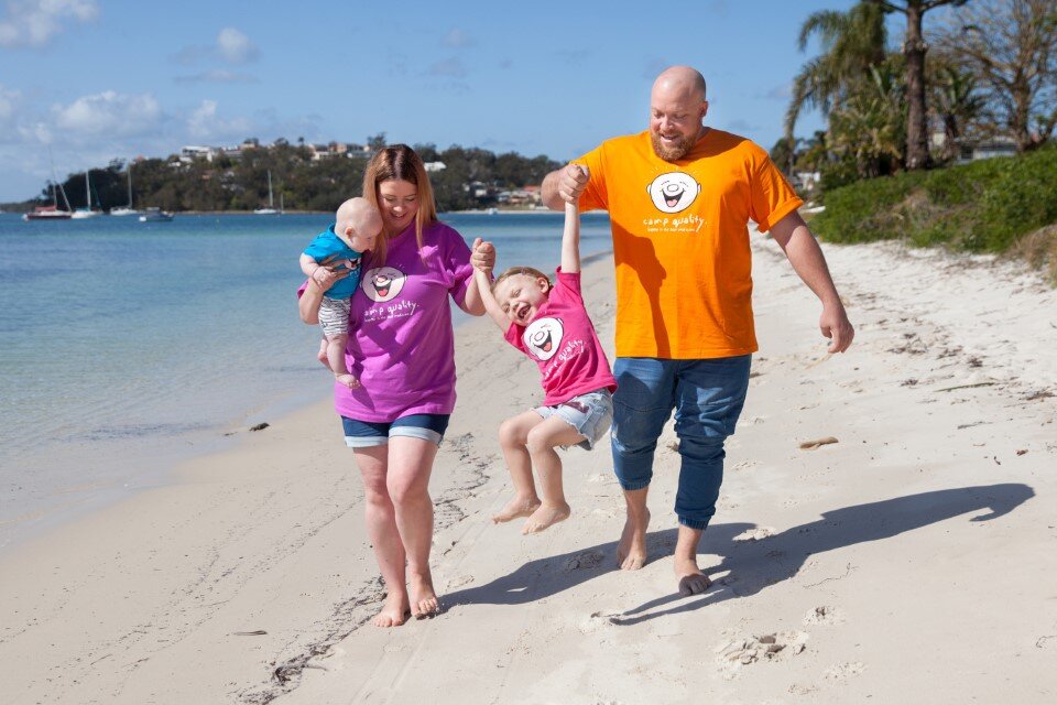 family on a beach wearing camp quality tshirts