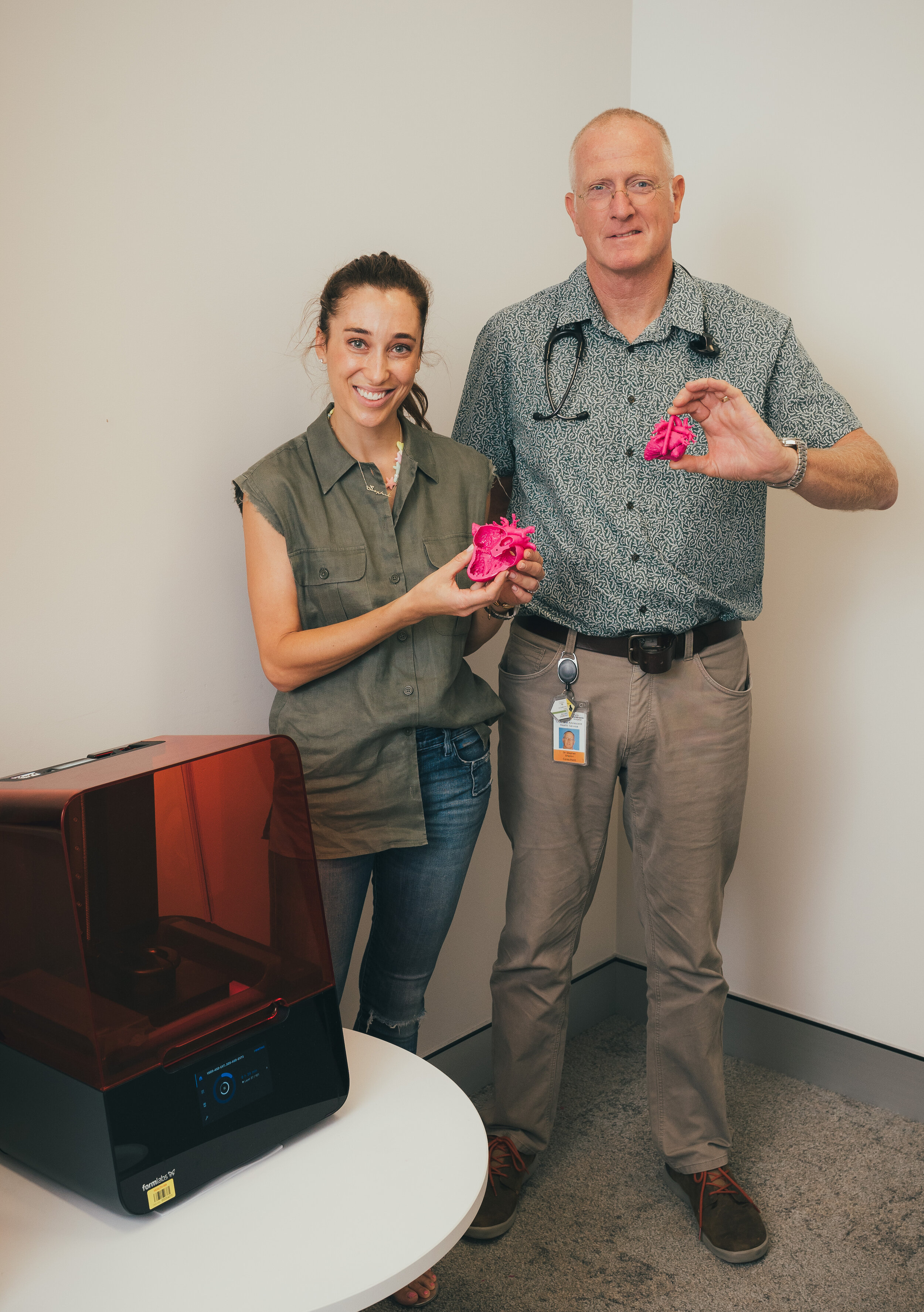 man and women holding 2 printed 3d hearts