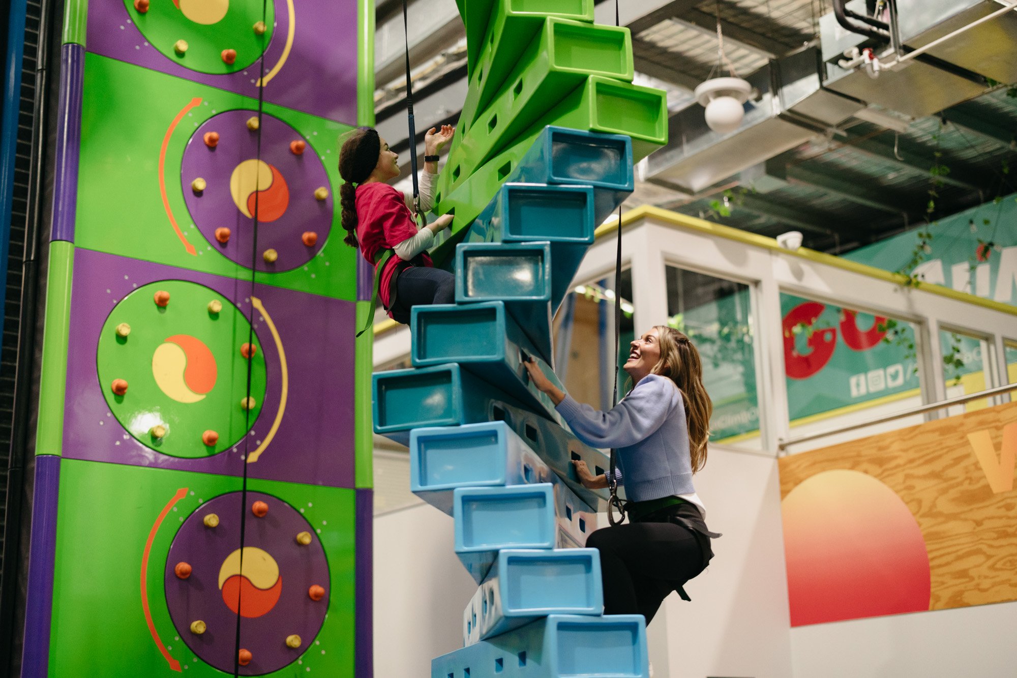 woman and child climbing a wall at adventure centre
