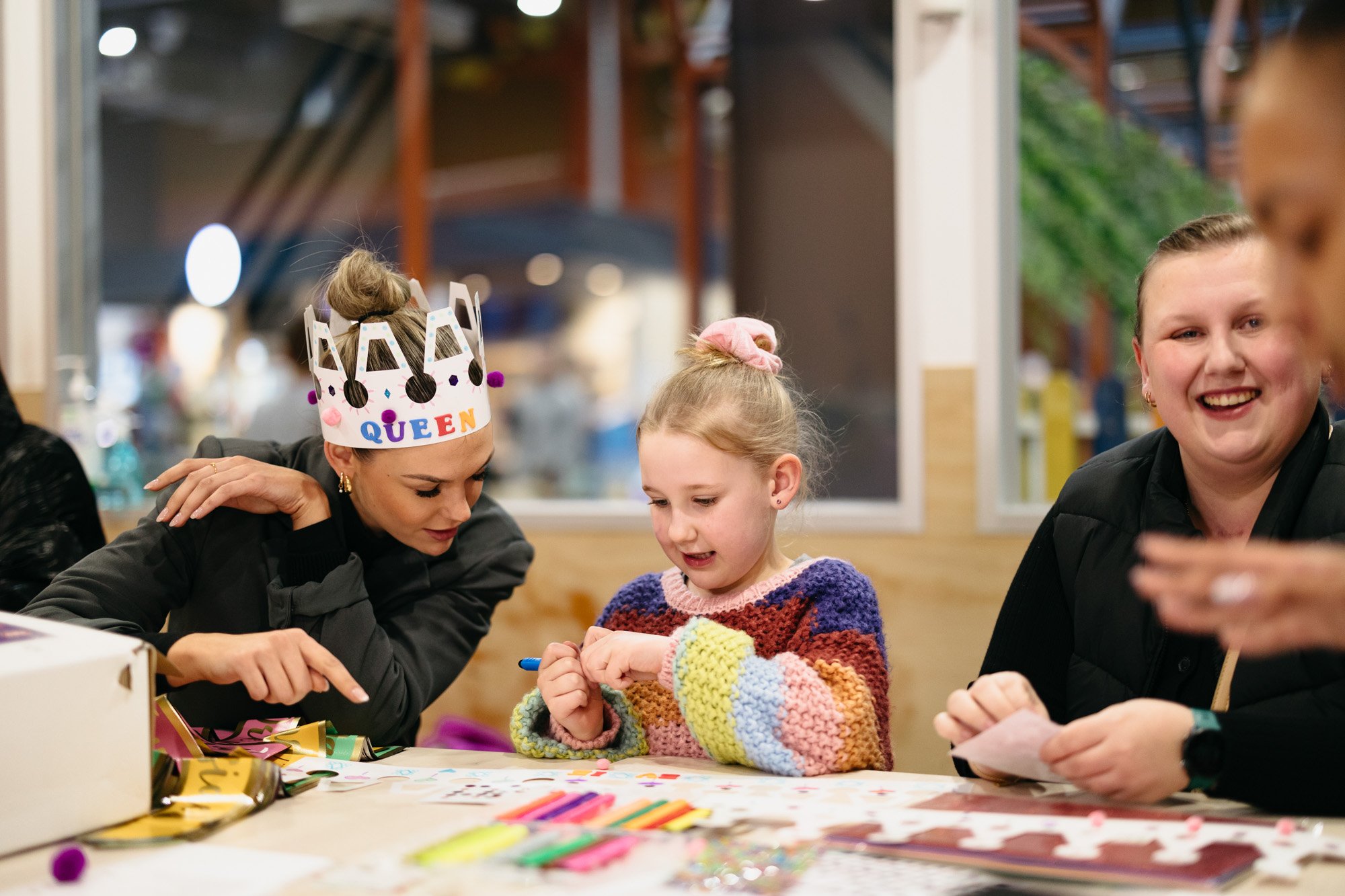 woman with paper crown playing with child