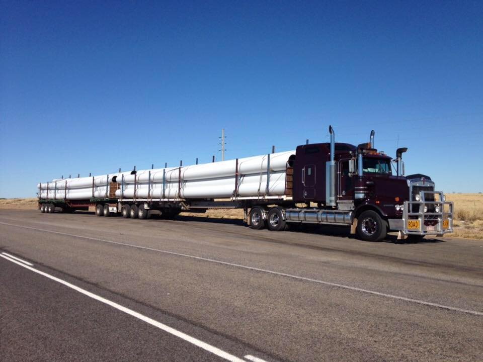Outback trucking with over dimensional, 20 metre length pipe and a triple road train configuration.