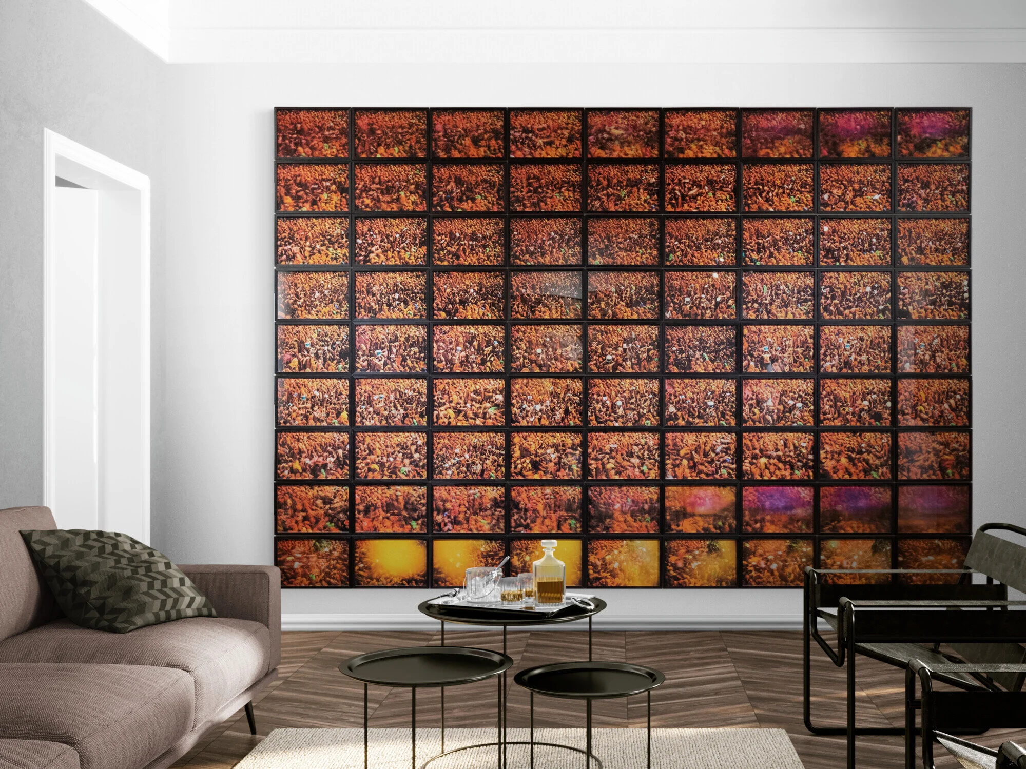 Ein Wohnzimmer mit einem großen Kunstwerk an der Wand, bestehend aus vielen kleinen Bildern, die eine orangefarbene Blumenwiese zeigen. Es gibt eine Couch, einen runden Tisch mit Getränken und zwei kleinere Tische, sowie einen schwarzen Stuhl am rechten Rand.