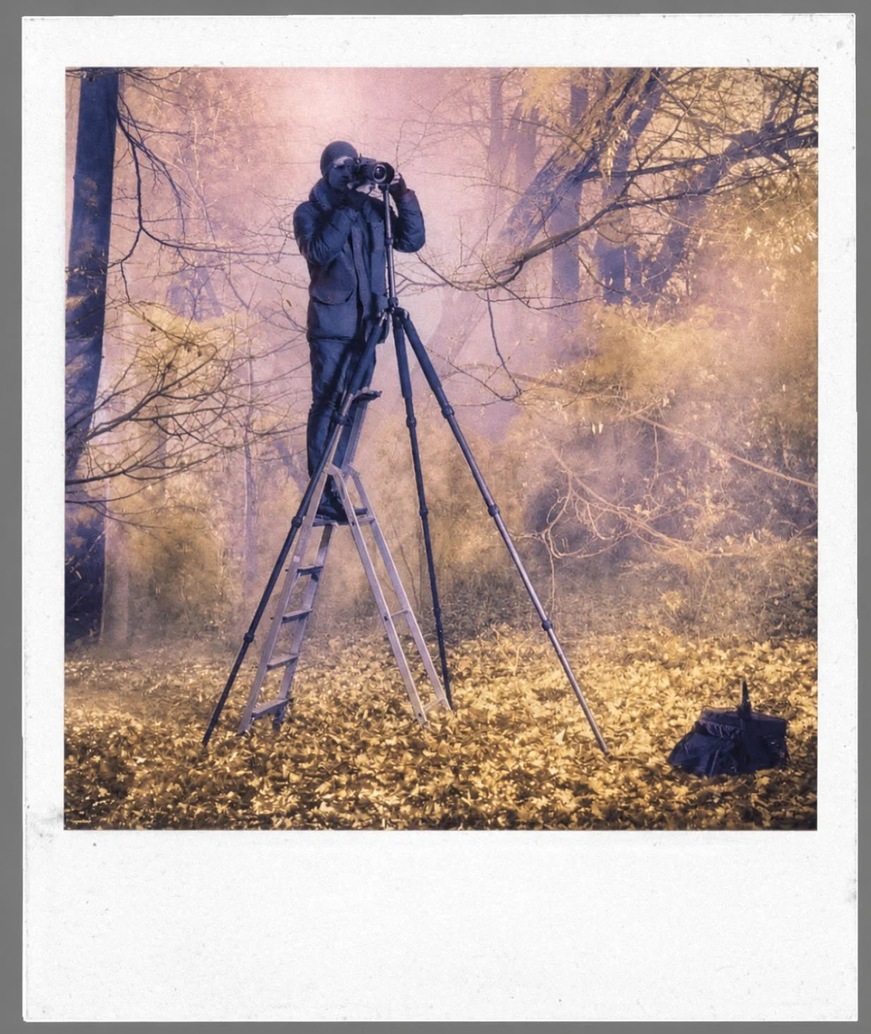 Fotokünstler André Wagner bei der Arbeit mit Kamera und Stativ während einer Infrarotaufnahme in einer Waldlandschaft.