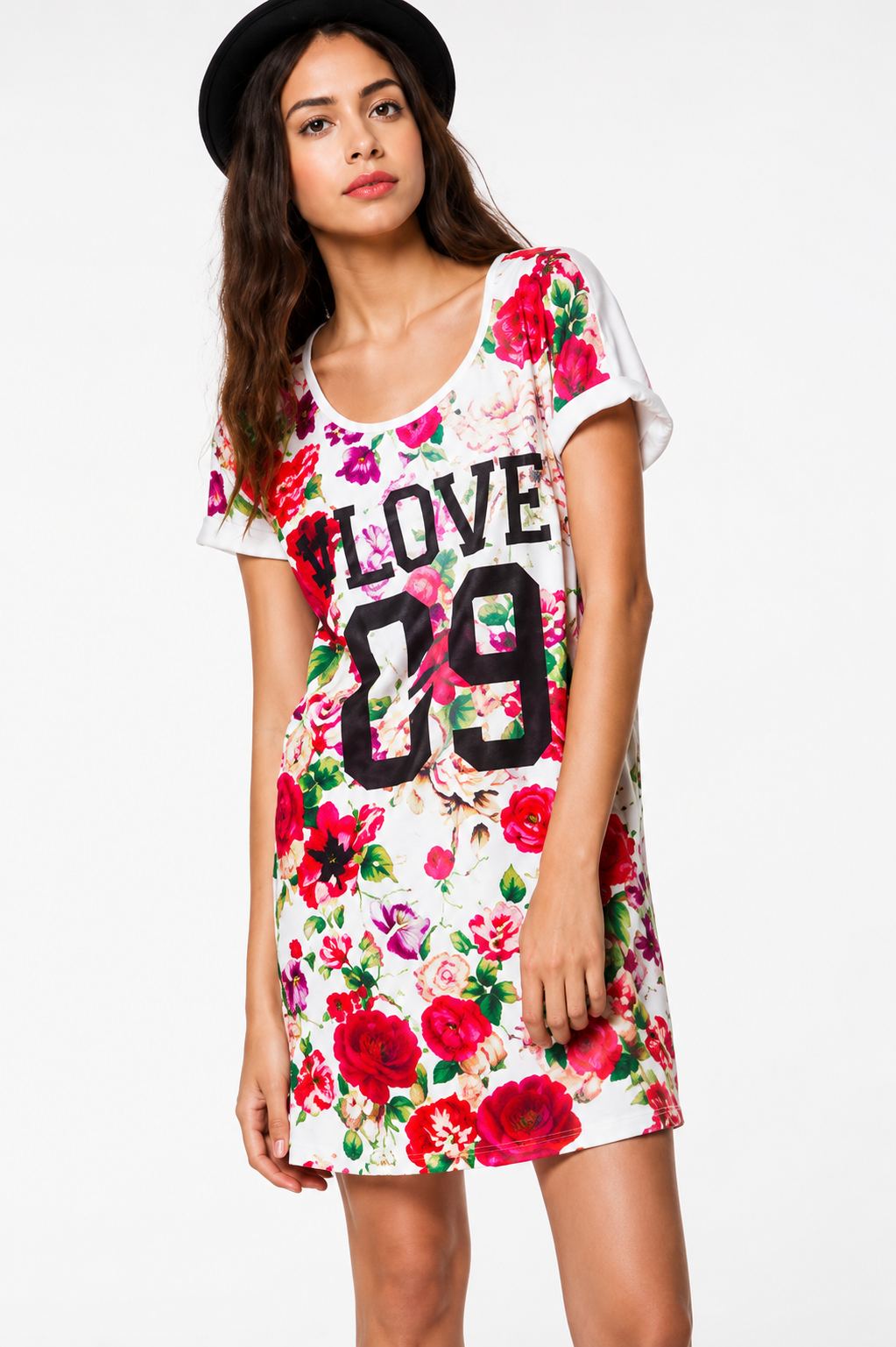A young woman with long brown hair wearing a black hat and a floral dress with the words 'LOVE 09' printed on it.