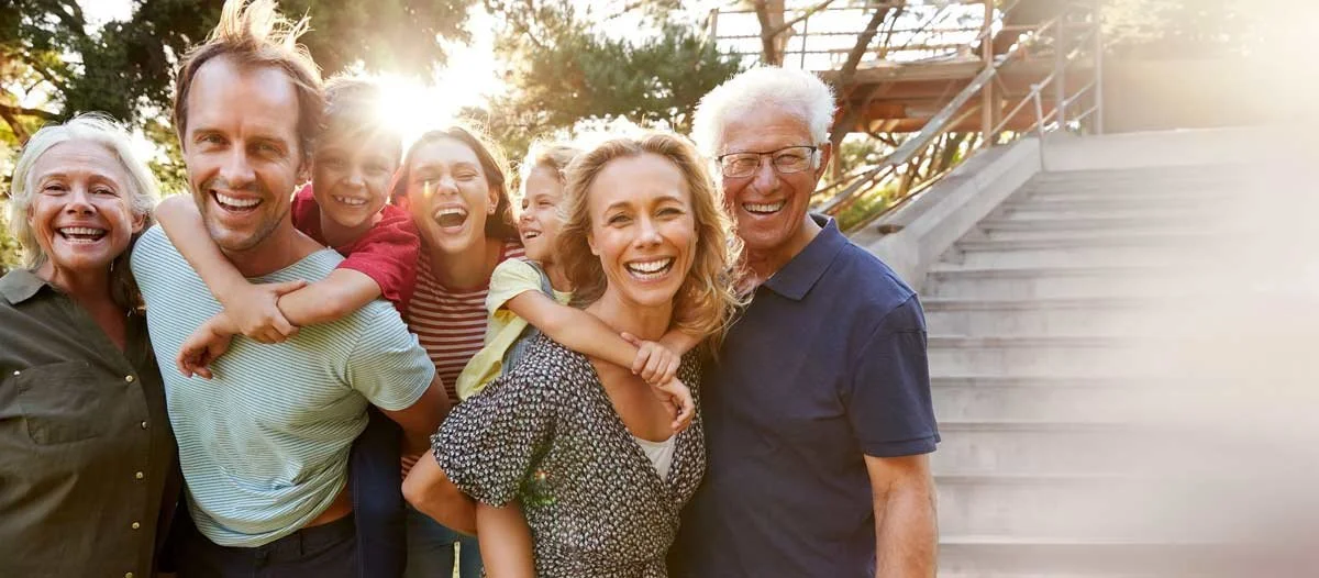 Eine lachende Großfamilie im Freien als Symbol für gestärkte Beziehungskompetenz und Persönlichkeitsstärkung durch das Gordon Training.