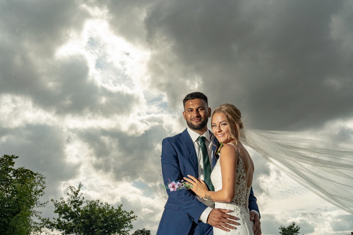 dramatic sky wedding portrait at Dodford Manor