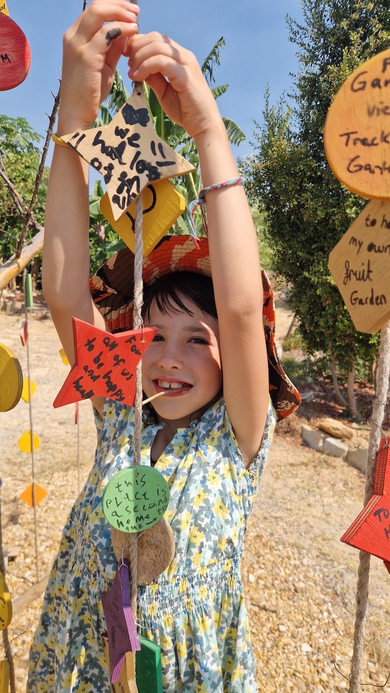 Kid hanging tablet on Wish Tree