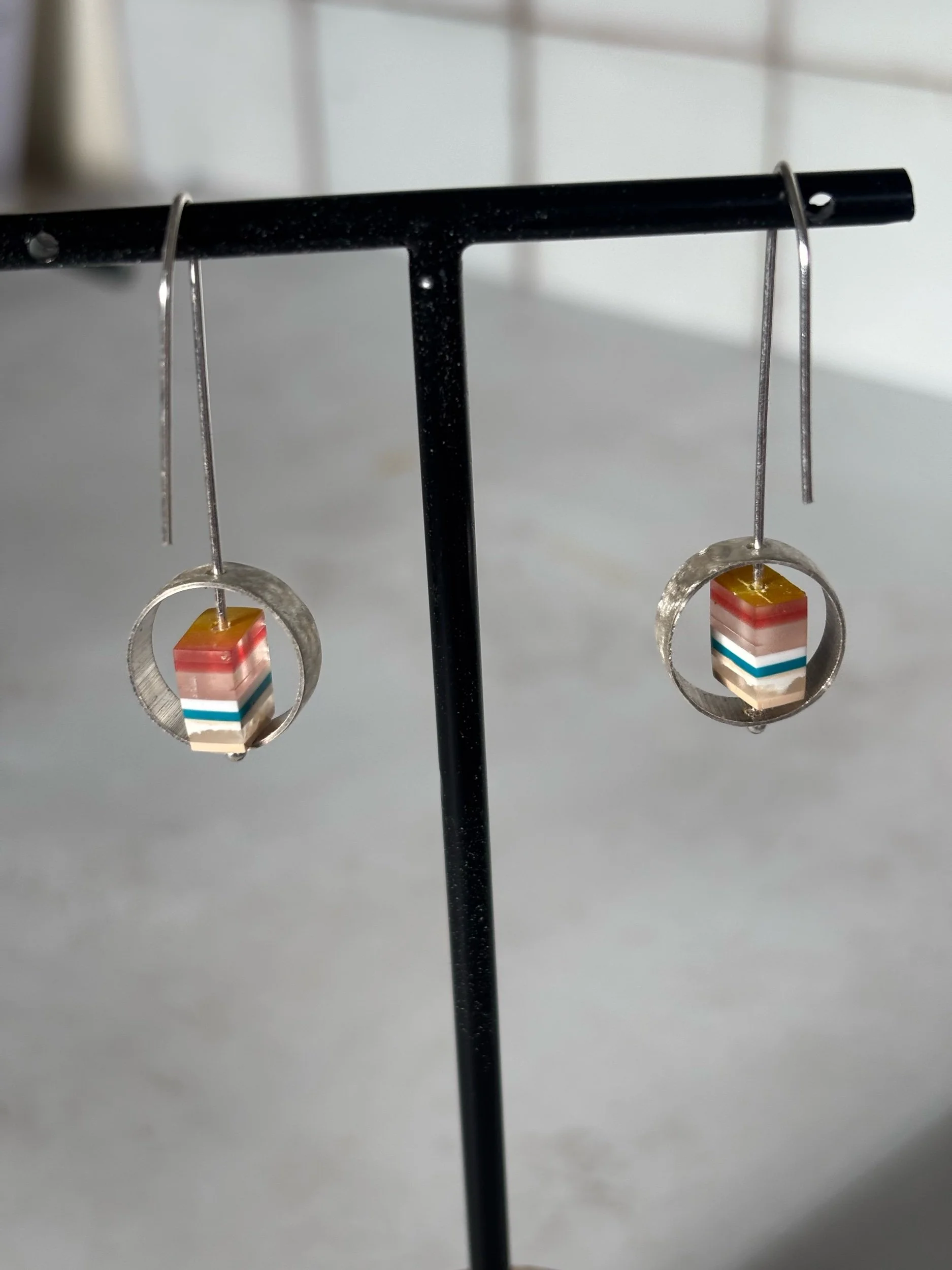 Handmade recycled silver earrings featuring textured bezels and layeres colour resin beads. Contemporary artisan jewllery designed for everyday wear