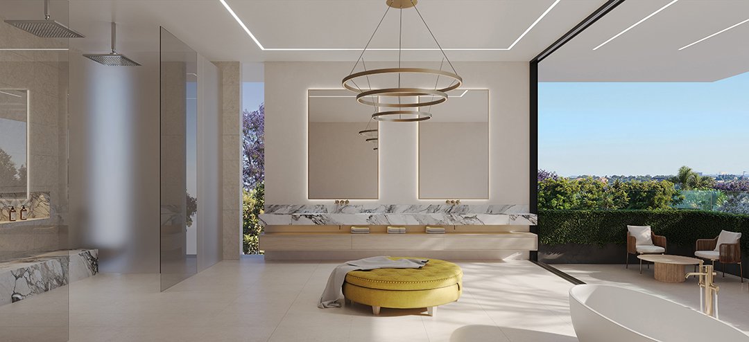 Modern interior bathroom with large windows showing a view of trees, a yellow ottoman, a marble-topped vanity, and a separate seating area with chairs and a round table.