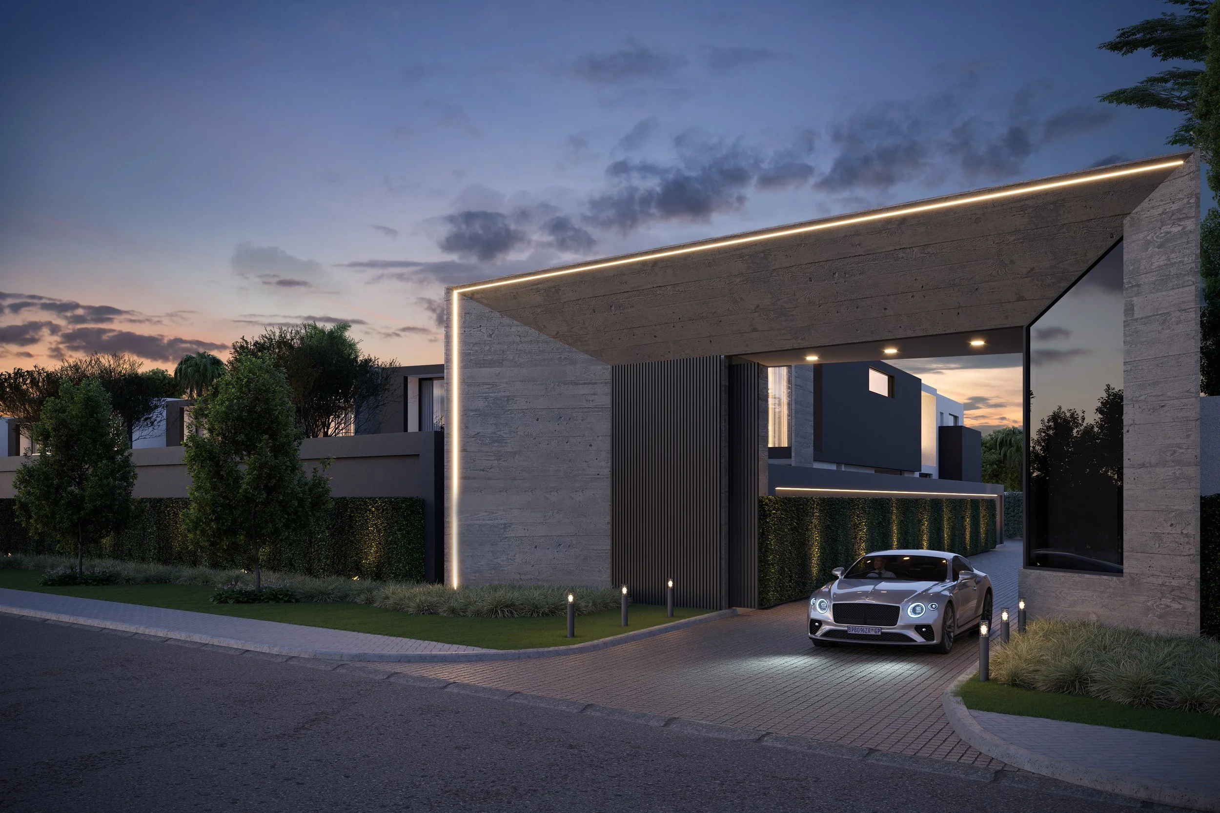 Modern building with a large overhang illuminated with LED strip lights at dusk. A silver sports car is parked underneath. Green trees and bushes surround the building, with a sidewalk and a paved road in the foreground.