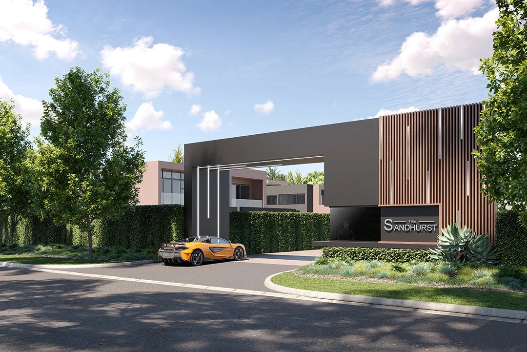 Modern gated residential entrance with landscaping, an orange sports car parked in front, and a sign reading 'The Sandhurst'.