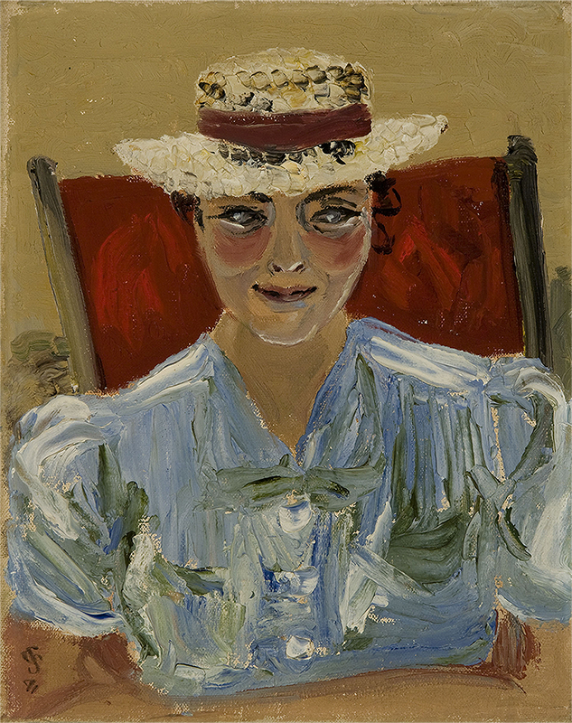  A woman in a blue top and white hat sitting on a red chair 
