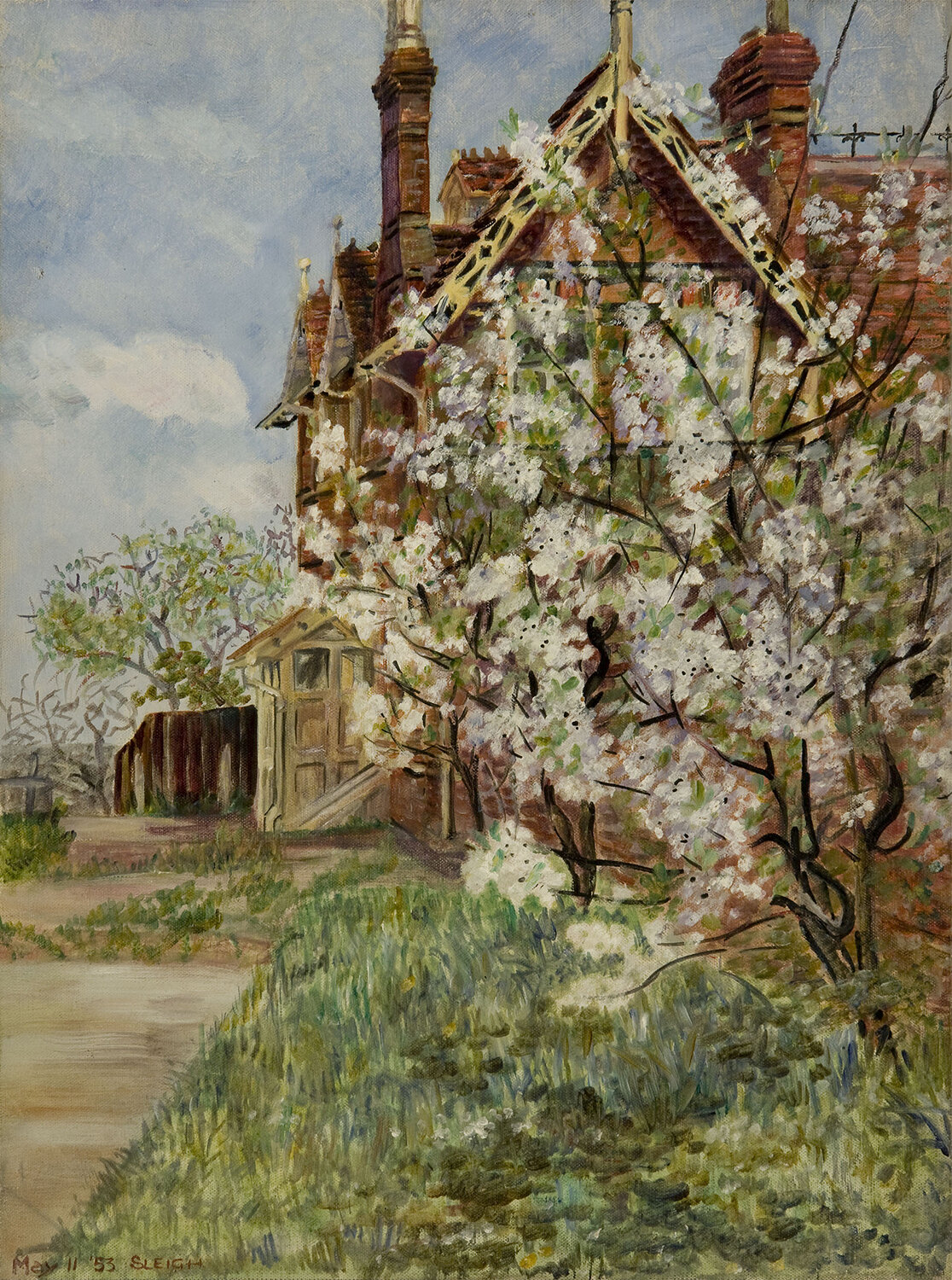  A brick building to the right of a path with a field and cherry blossom tree in front 