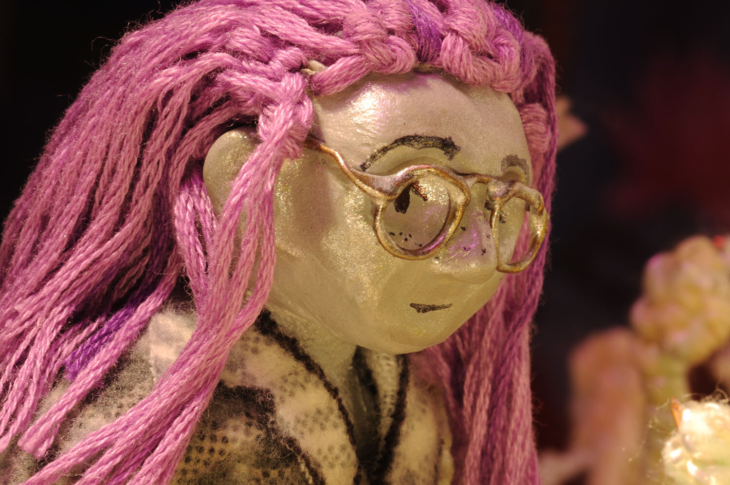  Claymation by Nisha Ramnath. Closeup of a girl with pink hair and glasses. 