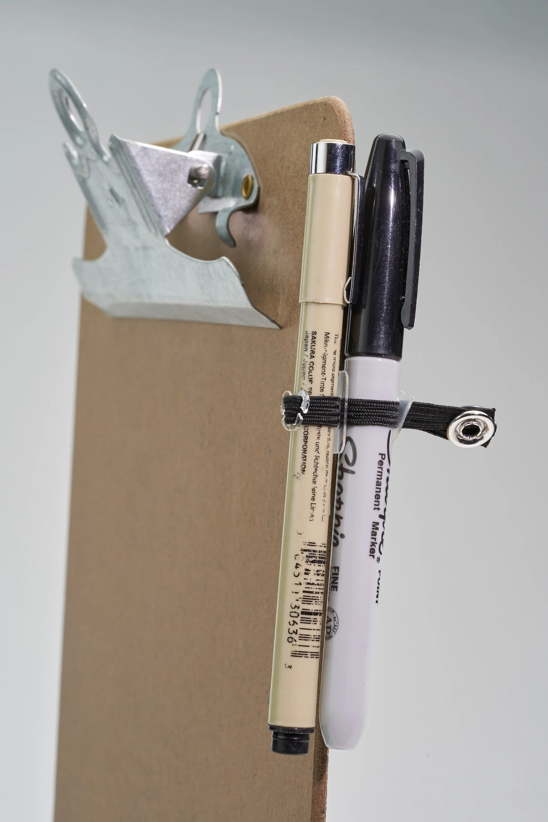 Flat Version holding a marker and pen.