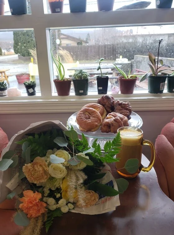 Latte, bouquet and locally made baked goods
