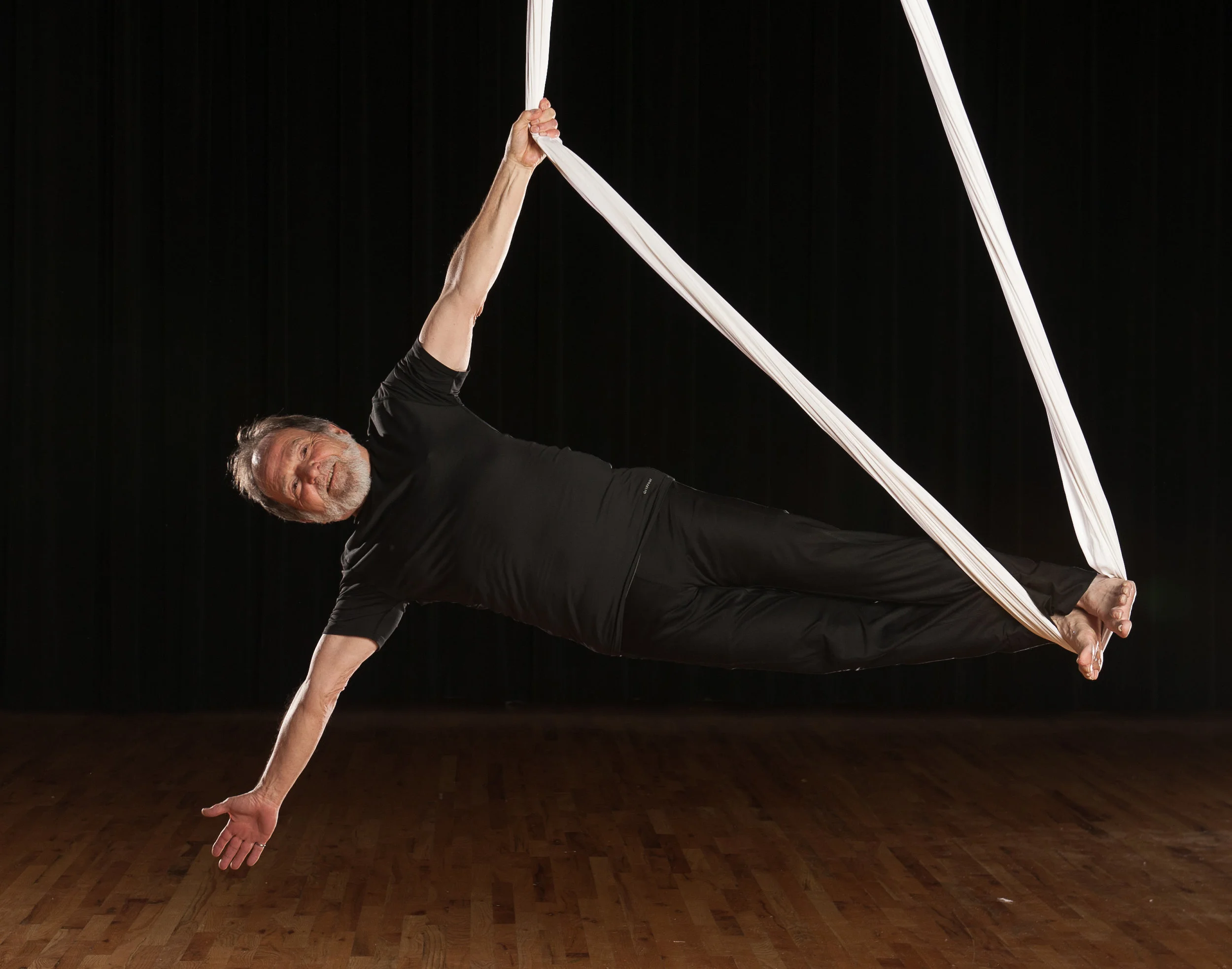 Alex Harrington performing aerial yoga.