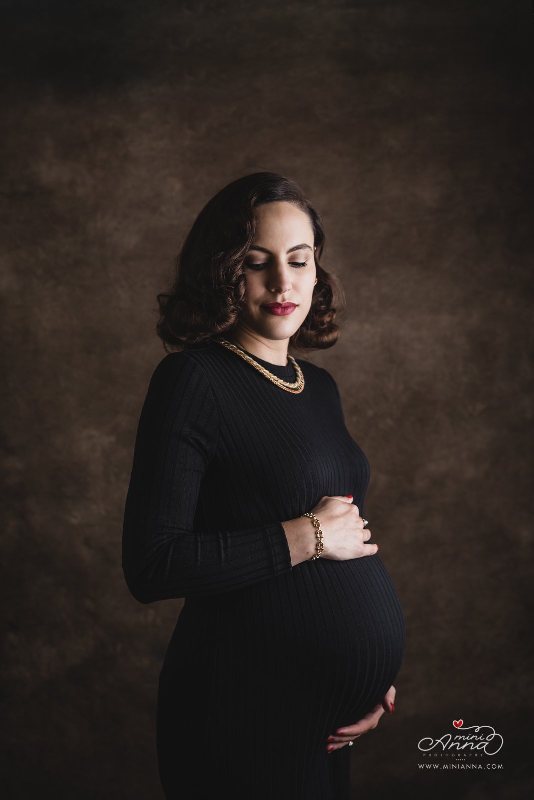 Mother-to-be holding belly during maternity session at Mini Anna’s studio