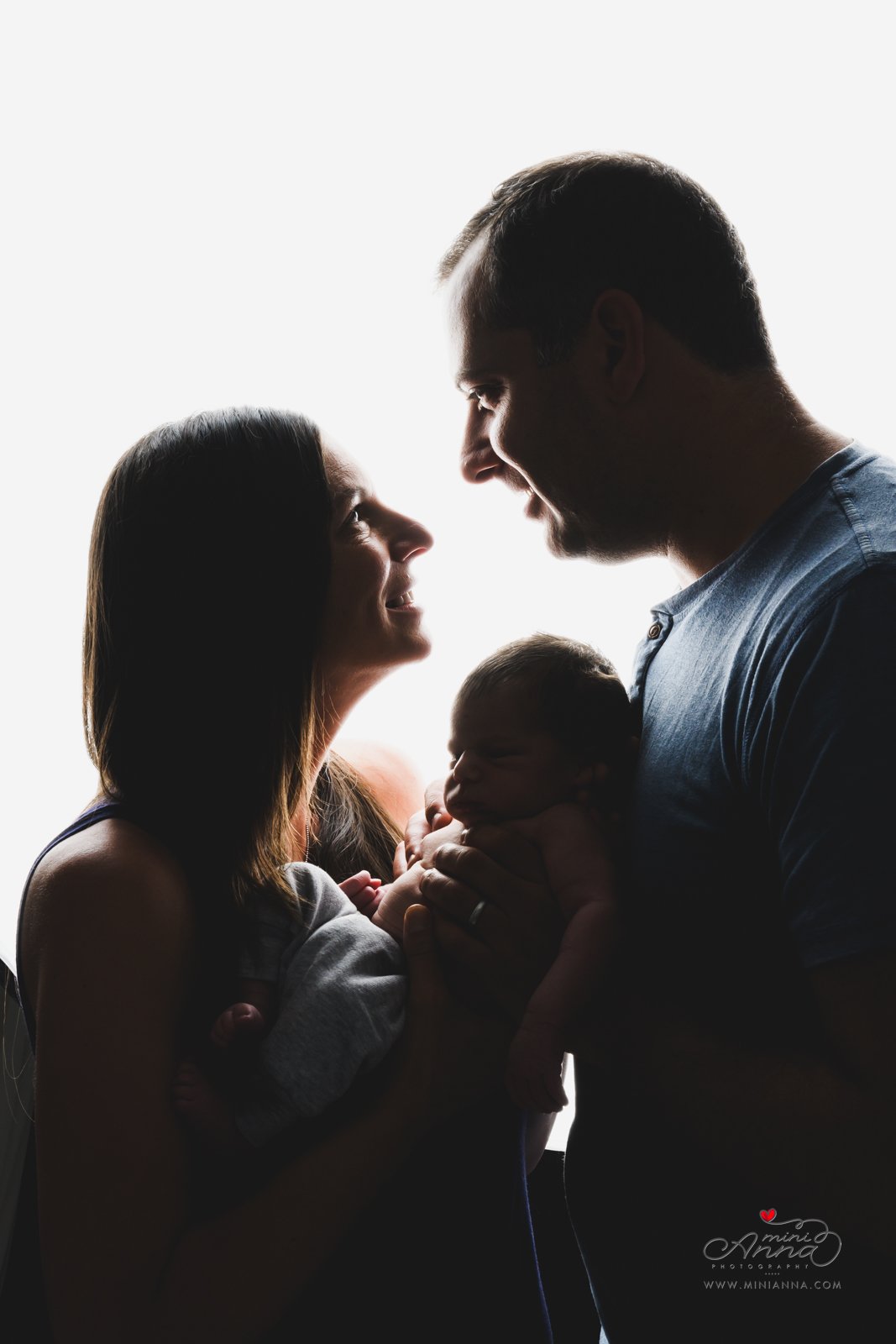 backlit family portrait with newborn