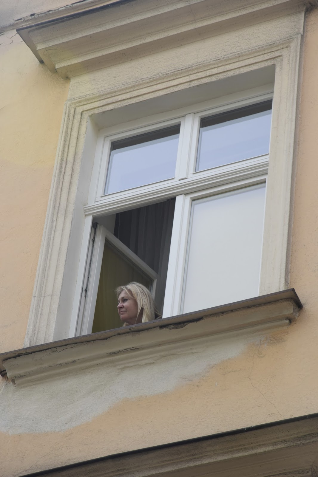 Woman gazing out window, Krakow, Poland