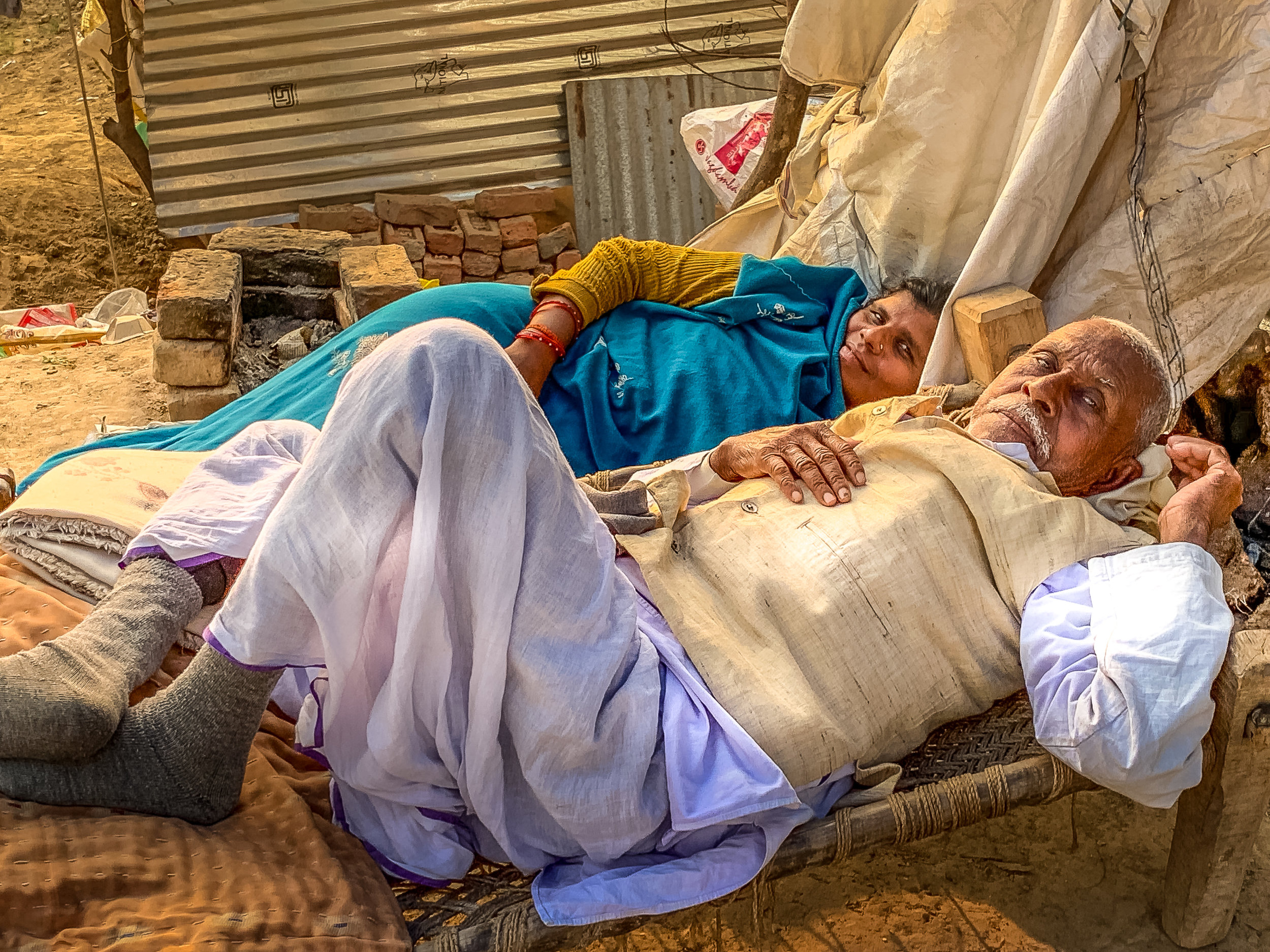Couple resting at the Kumbh Mela, Prayagraj, India