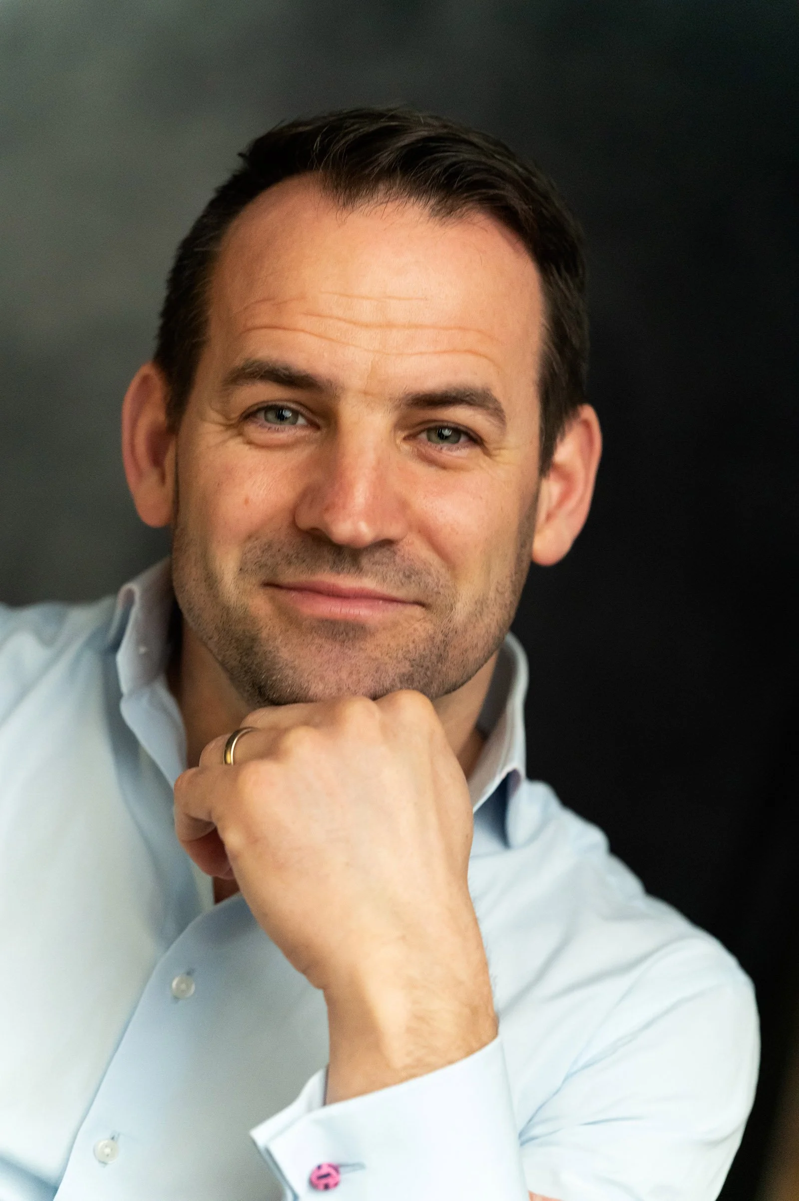 Corporate headshot of man wearing white shirt.