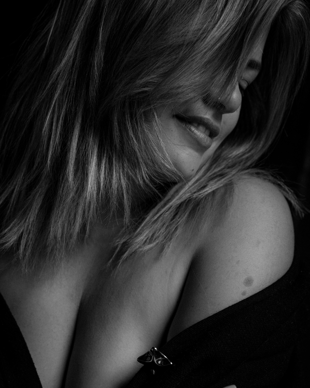 Boudoir portret van een vrouw die zacht glimlacht in ZOOM Fotoatelier Lichtervelde, gefotografeerd door Wendy De Craemer.