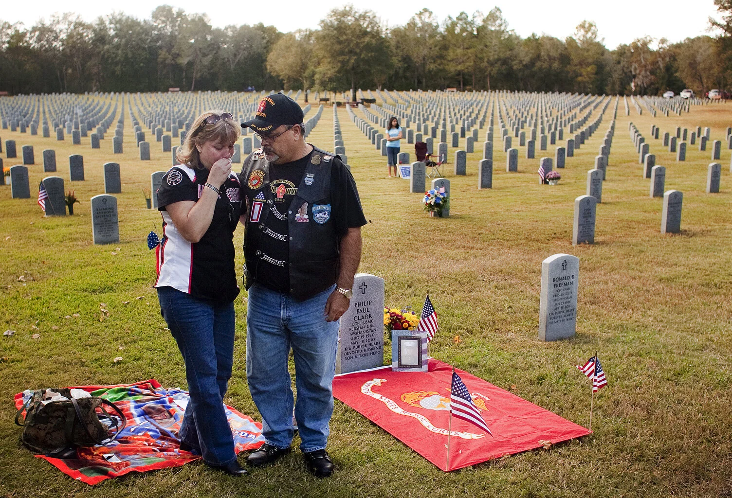  During the rifle salute by the Florida National Guard, Mike Clark (cq) 45, right, consoles his wife Tammy both of Gainesville remember their son Lance Corporal Philip Clark while standing next to his grave during the Veterans Day program on Sunday. 