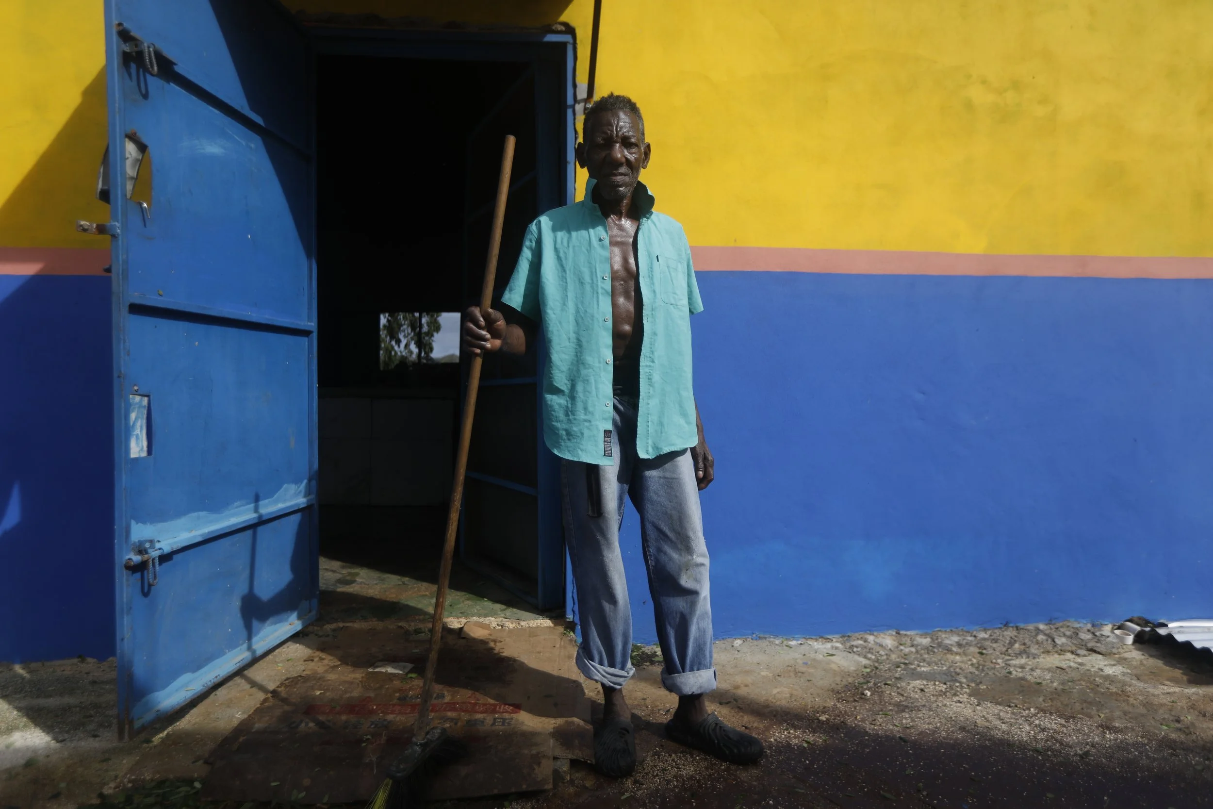 Leroy Brown holds a broom in front of a restaurant after Hurricane Melissa made landfall in Alligator Pond, Jamaica, on October 29, 2025. REUTERS/Octavio Jones