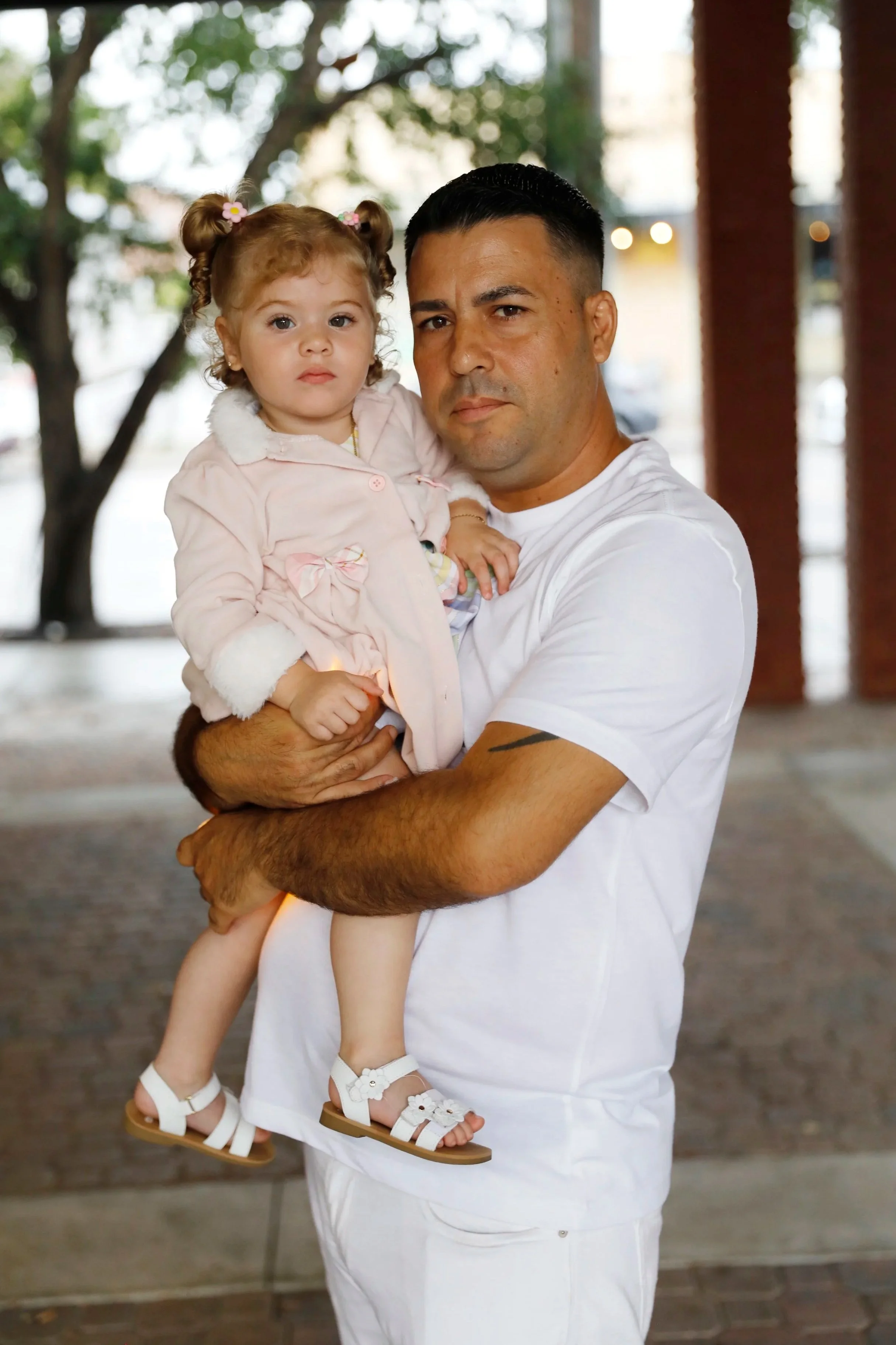 Carlos Valle, husband of Heidy Sanchez, holds their one-year-old daughter, Kailyn, after a vigil at Centennial Park in Ybor City, Tampa, Florida, on Saturday. The event was held to support and raise awareness for Sanchez and other undocumented immigr