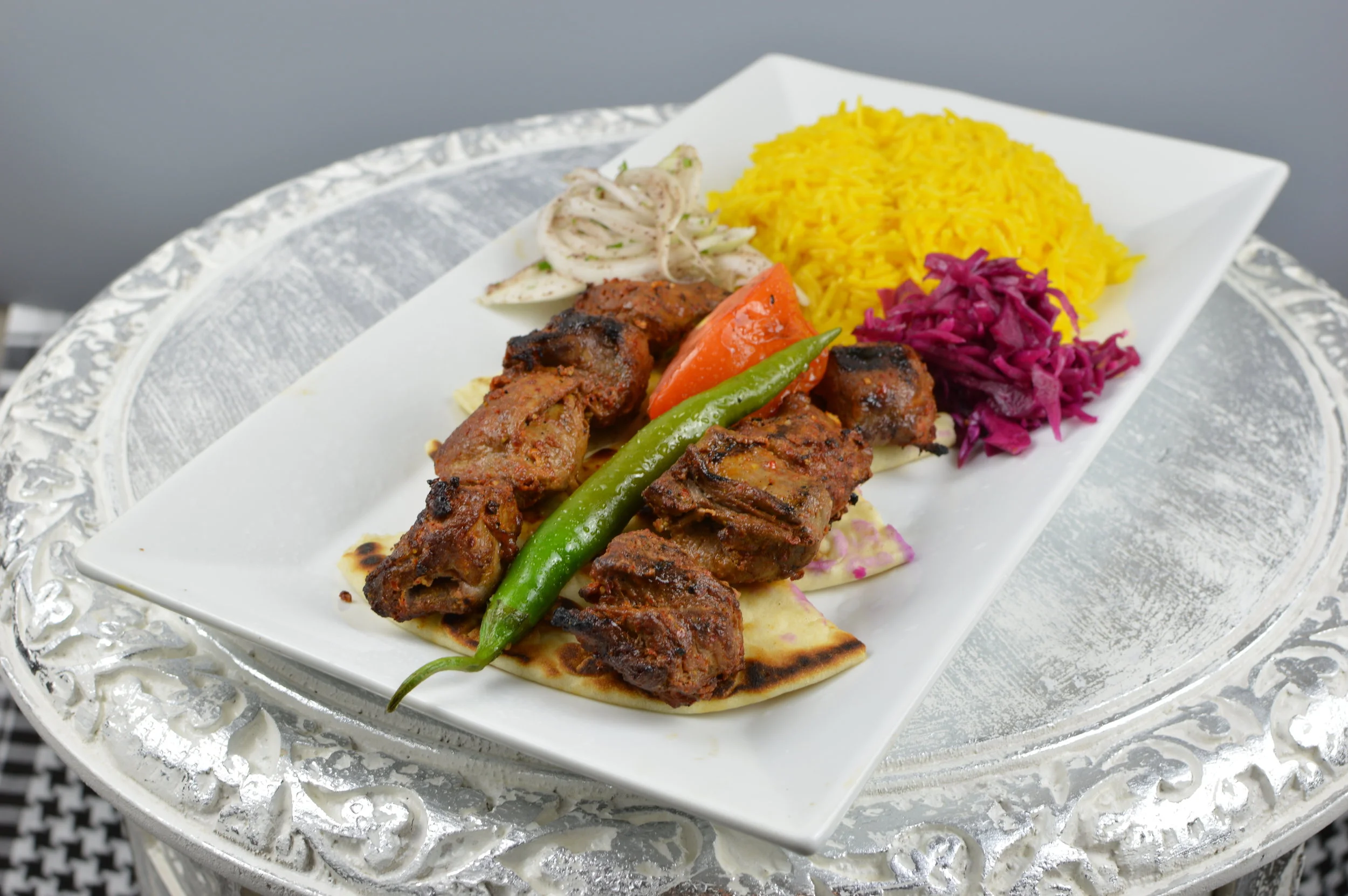 Kuzu Sis (Lamb Shish Kabob) - Two skewers of chargrilled cubes of marinated baby lamb. Served with rice and salad. $13.95
