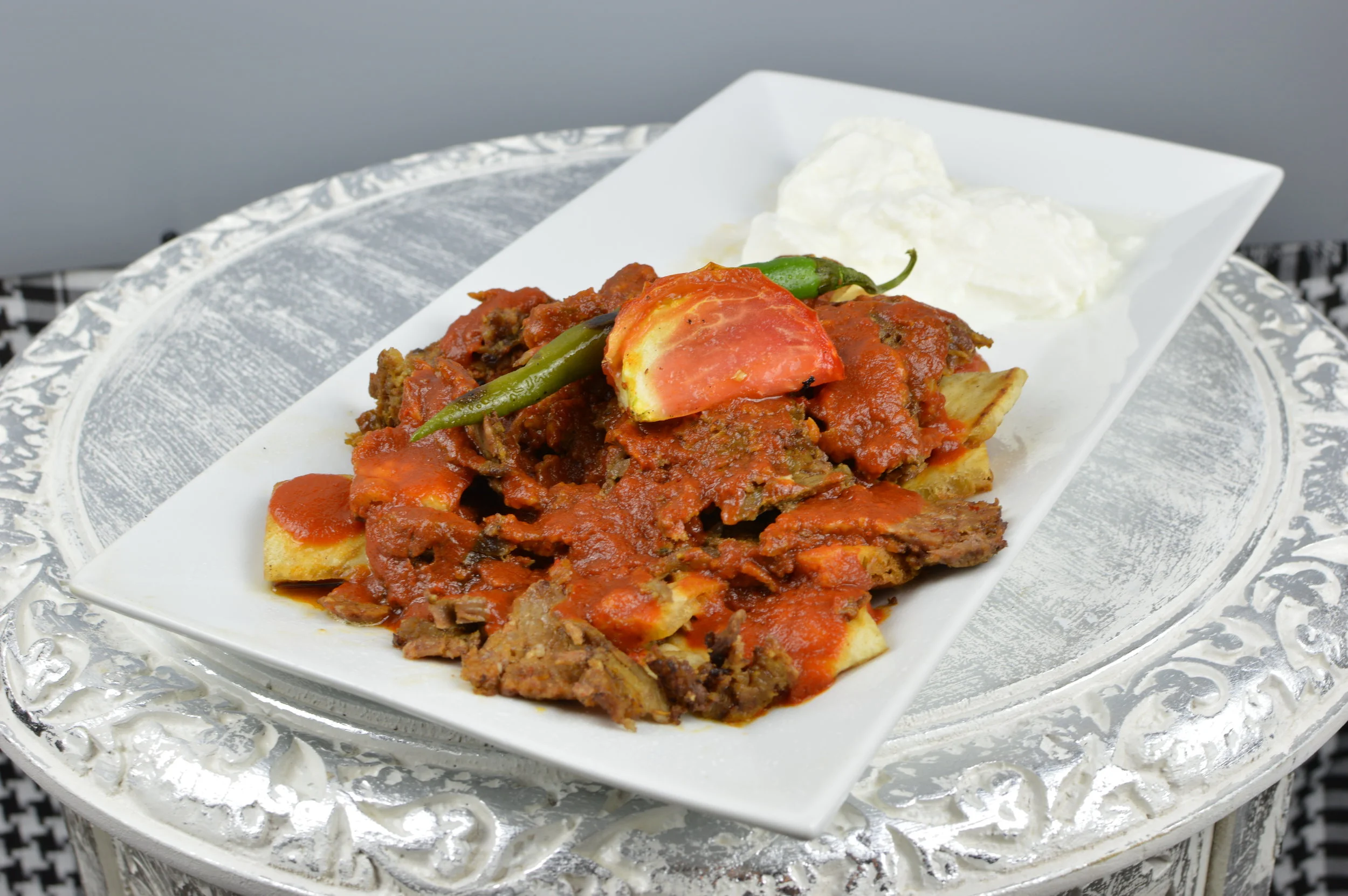 Iskender Kabob - Doner (shawarma), served over buttered bread, topped with savory tomato sauce and yogurt. Served with salad. $13.95