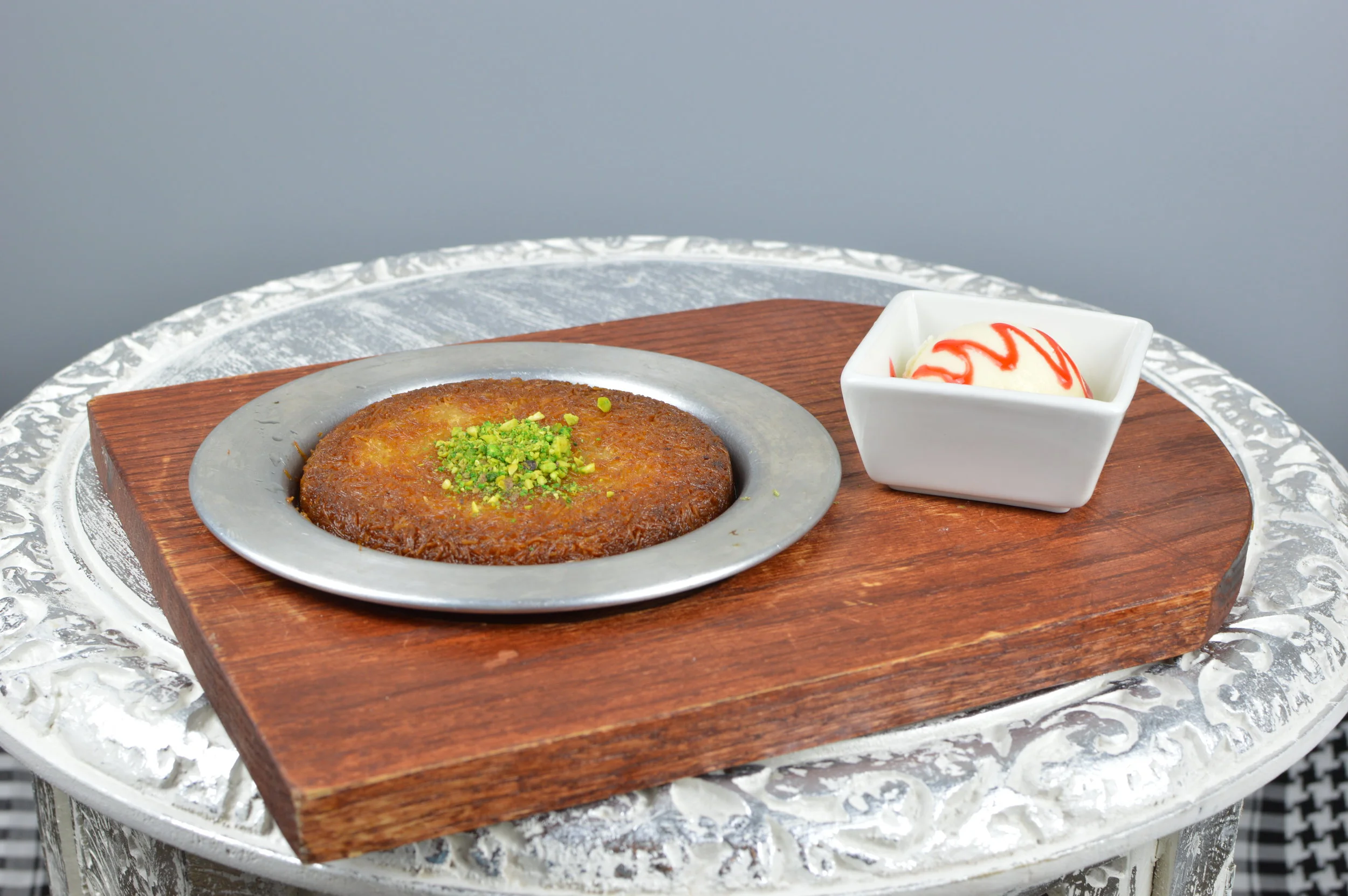 Turkish Kunefe - Shredded wheat with a layer of melted cheese, topped with chopped pistachios and aromatic sweet syrup. Served with ice cream. $7.95