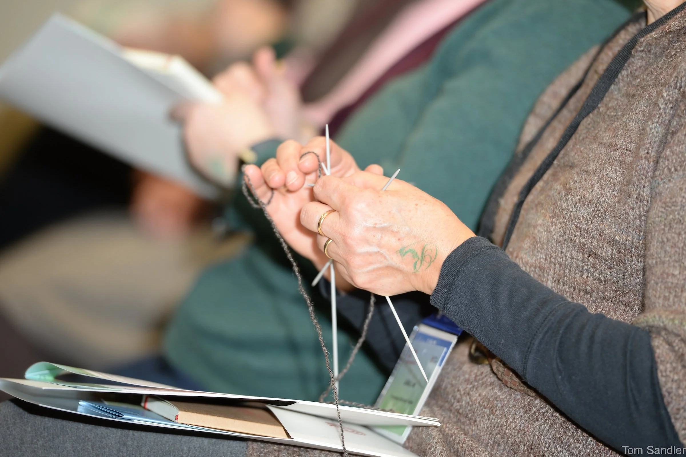 Les participants à la conférence tricotent et prennent des notes