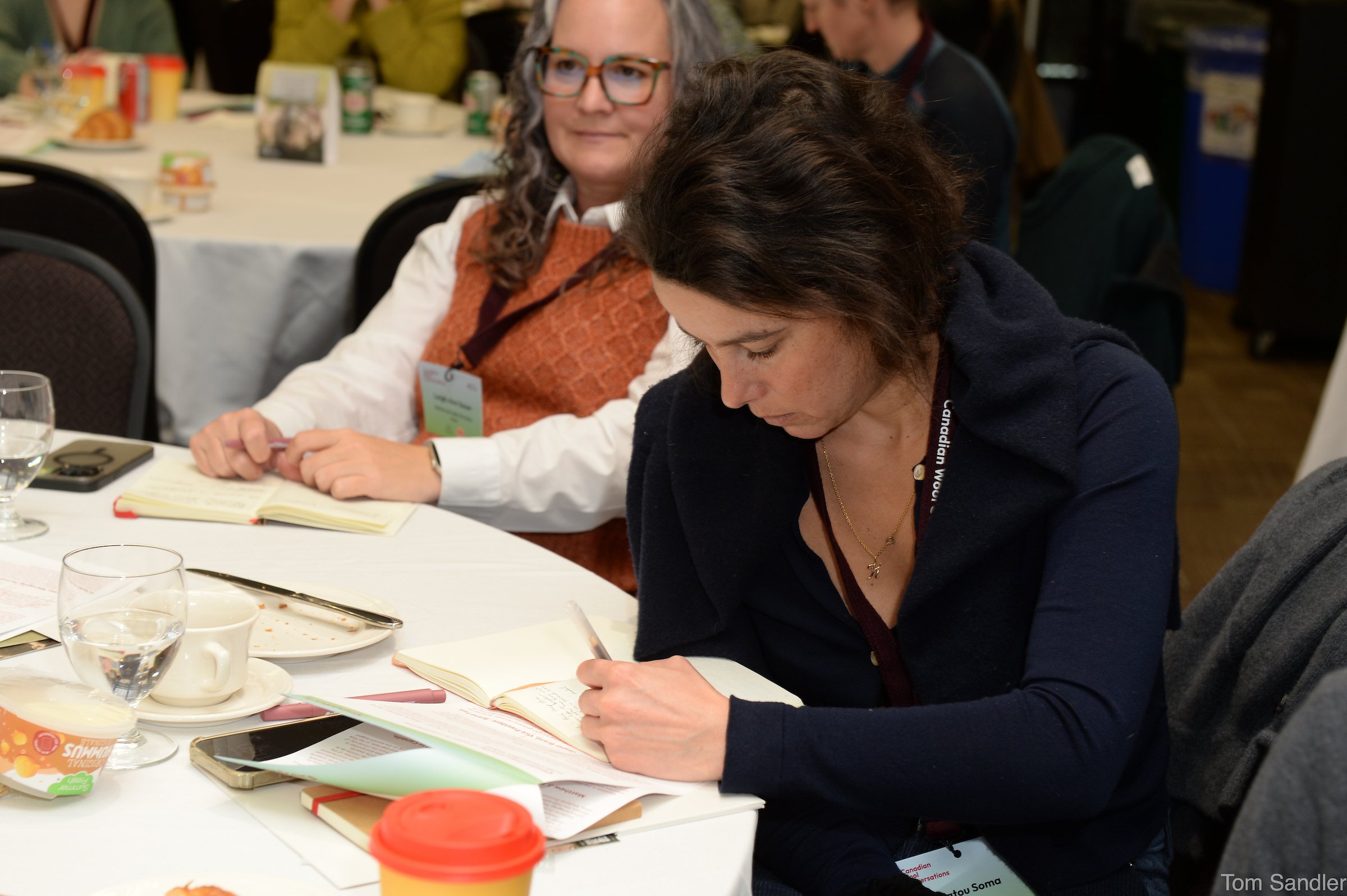 Les participants à la conférence prennent des notes.