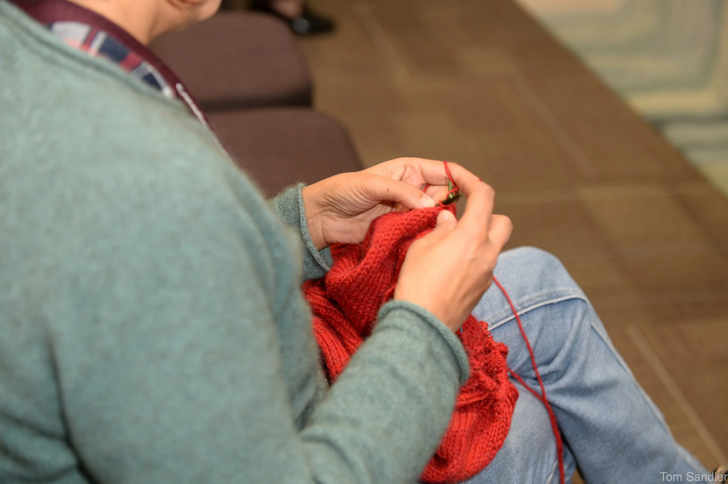 Les participants à la conférence tricotent tout en écoutant les tables rondes.