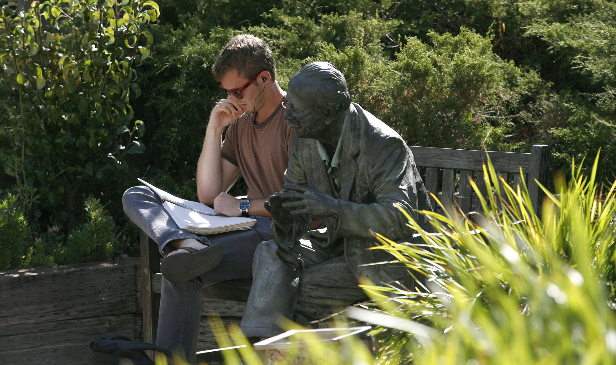 Student reading on a bench in campus