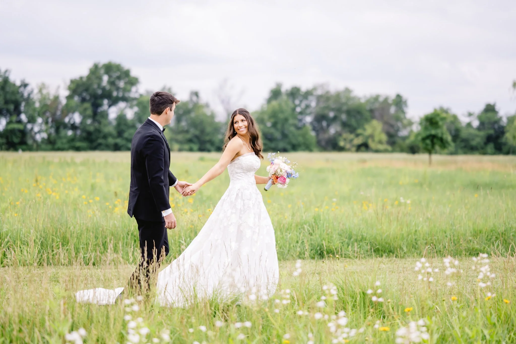 bride and groom walking through Emerson Fields in June in Missouri