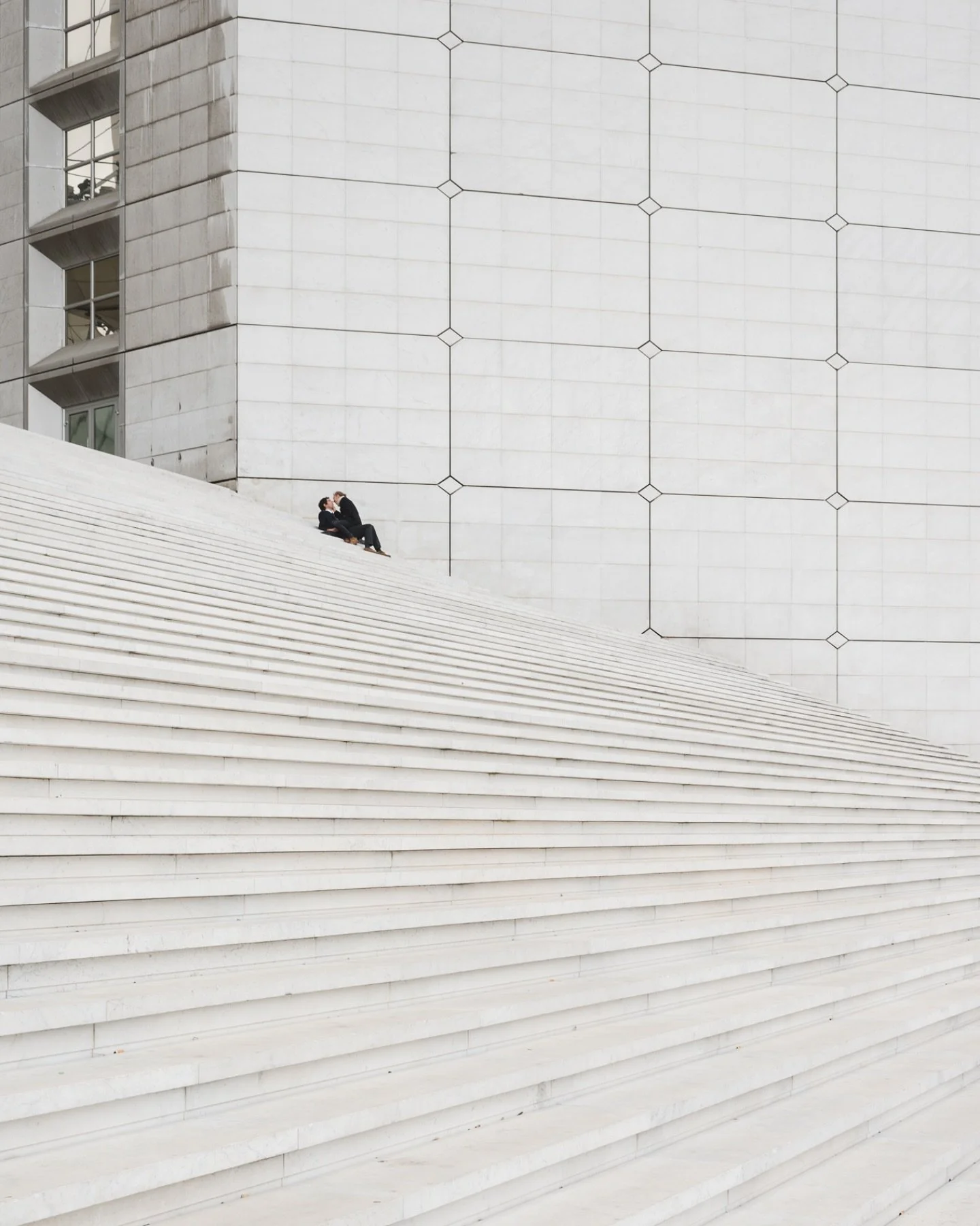 A quiet moment in Paris.  Amid the symmetry and structure, love finds space. #Paris #Minimalism #LoveInTheCity #StreetPhotography #ArchitecturalPhotography #MomentOfCalm #UrbanRomance #GeometryInLife #ModernLove #VisualPoetry