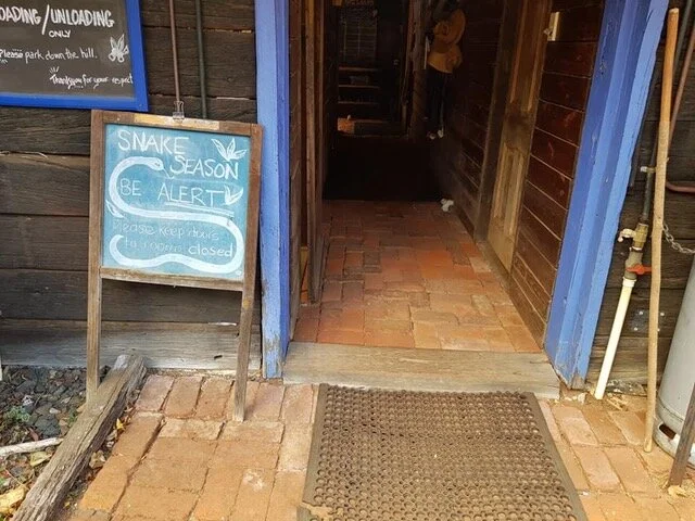 SNAKE SEASON WARNING SIGN AT THE ORIGINS MAIN HALL ENTRANCE