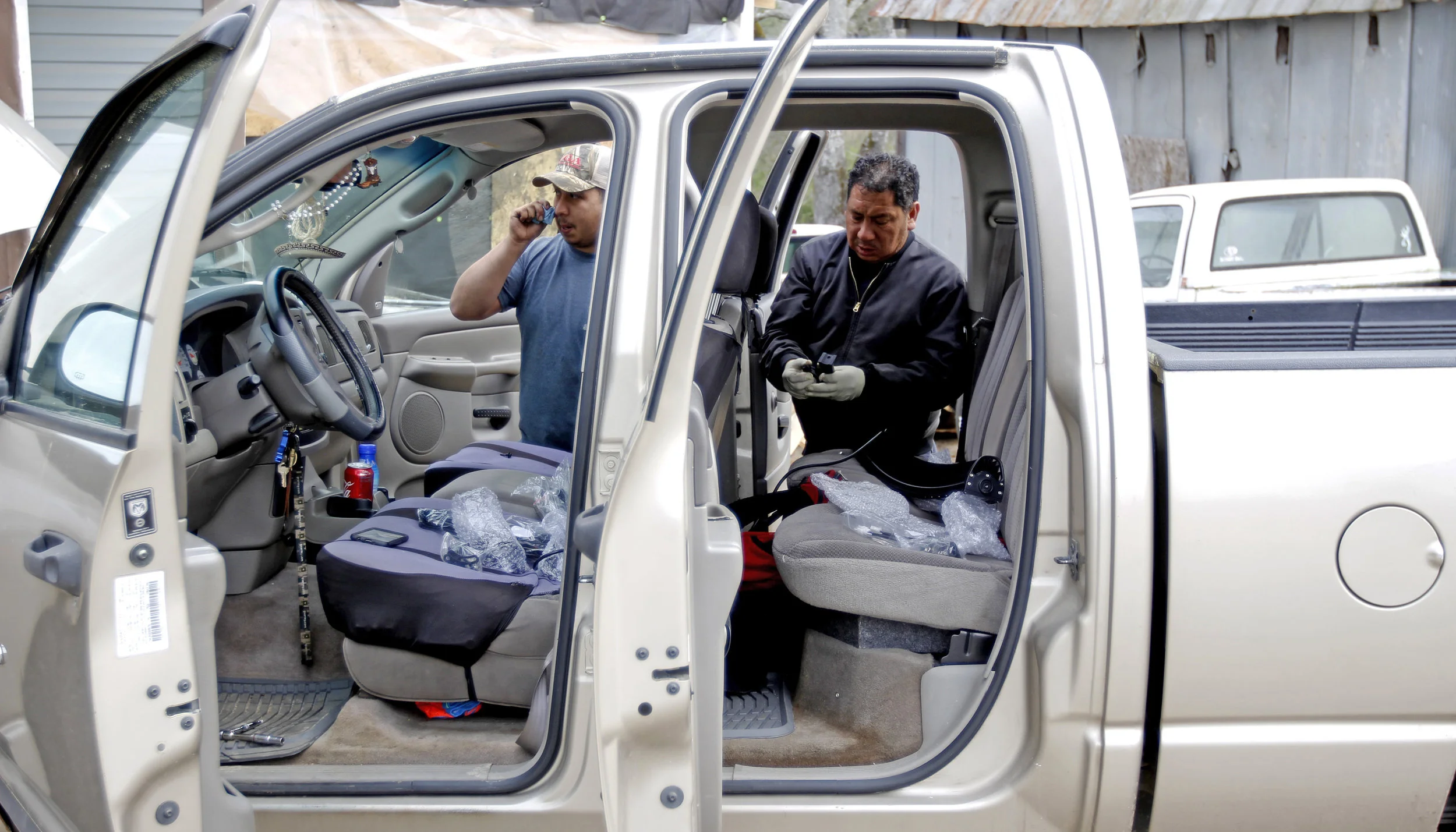  Andre Aparicio answers a phone call while his father runs diagnostics on a truck at Aparicio’s Garage in Greensboro, Georgia.  