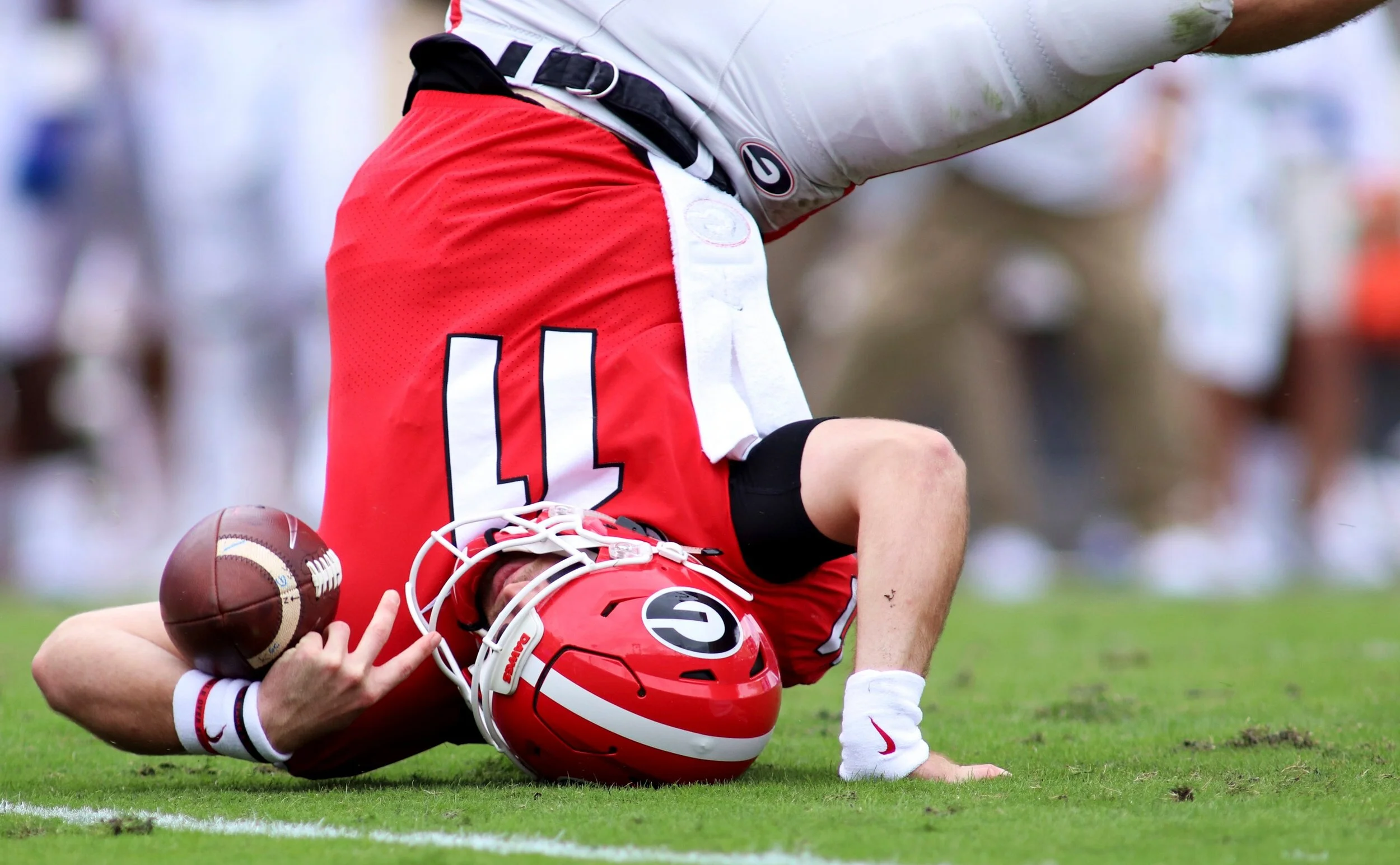  Jake Fromm, a sophomore quarterback, rolls on the ground after being sacked during the first half of the University of Georgia vs. University of Florida football game on Saturday, October 27, 2018, at TIAA Bank Field in Jacksonville, Florida. The Ge