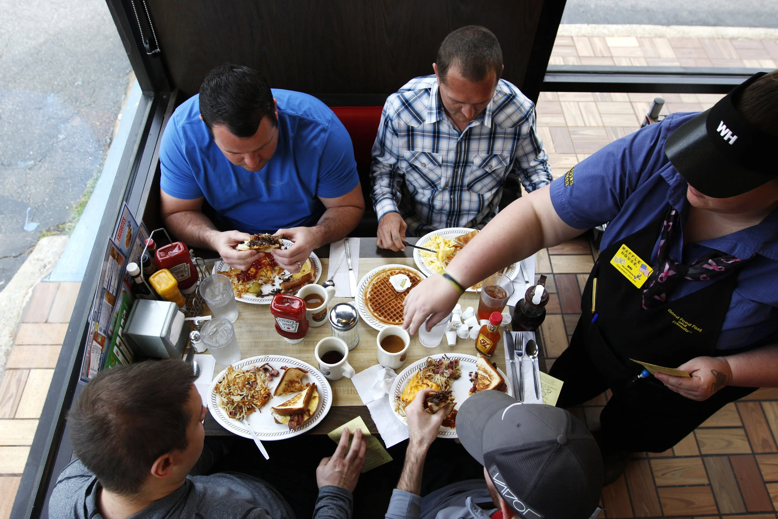  (Clockwise) Chris Canova, Tyler Gutzman, Tony Davis and Tad Newman eat at Waffle House in Greensboro, Georgia, on March 23, 2018.   