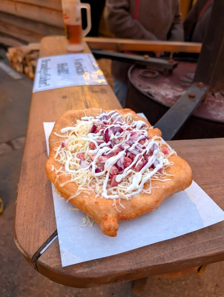 Langos, a bread snack with cheese, onions, ham and sour cream