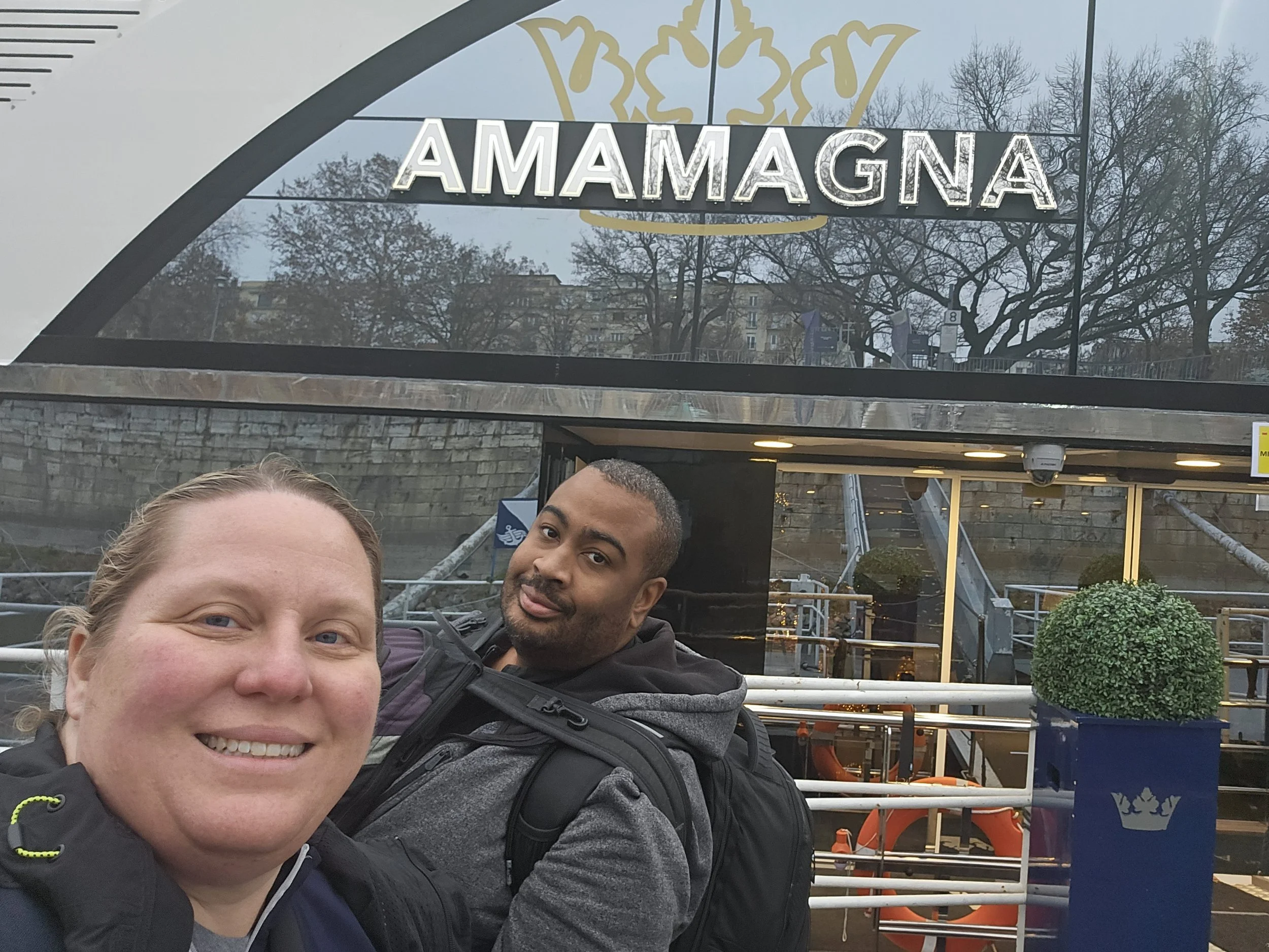 Anne and Tim pose in front of the entrance to the AmaMagna
