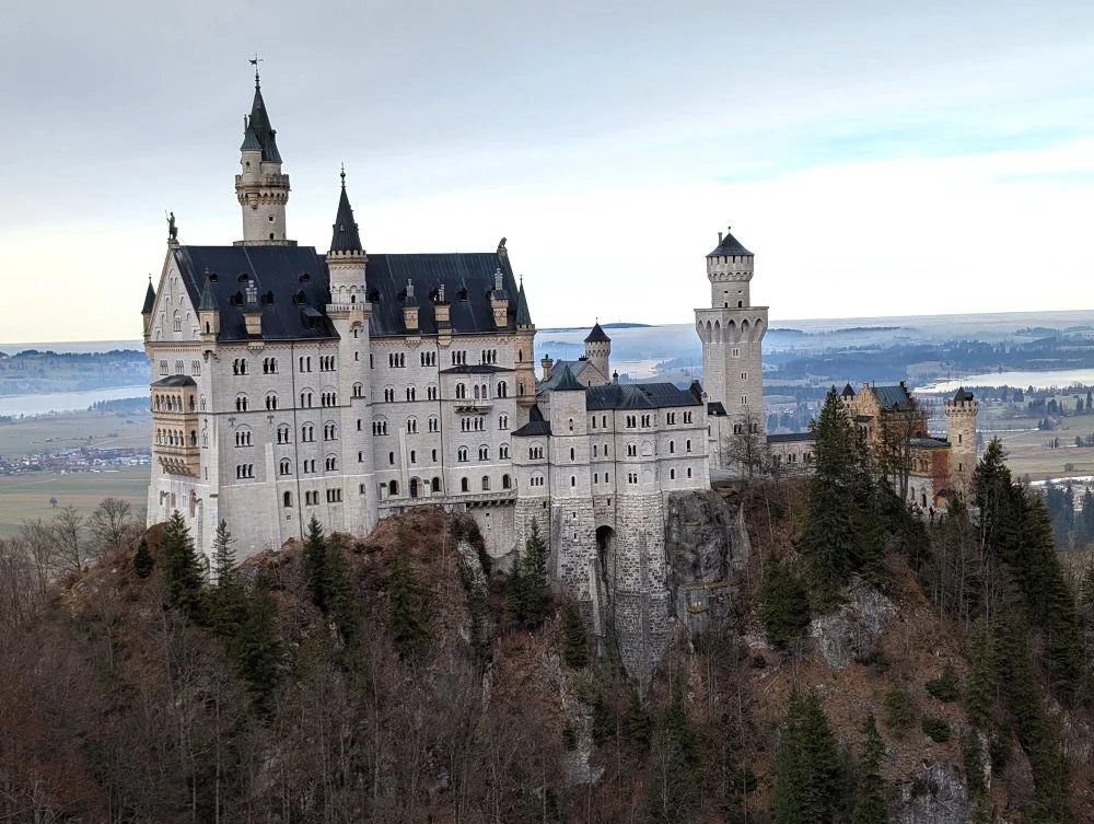 a view of Neuschwanstein Castle and the Bavarian countryside from a vantage point above the castle