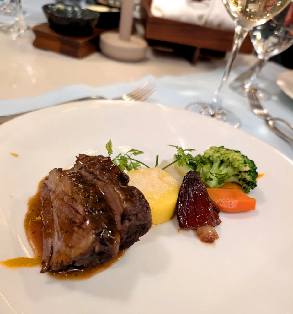 A dinner plate with sliced braised beef along with vegetables